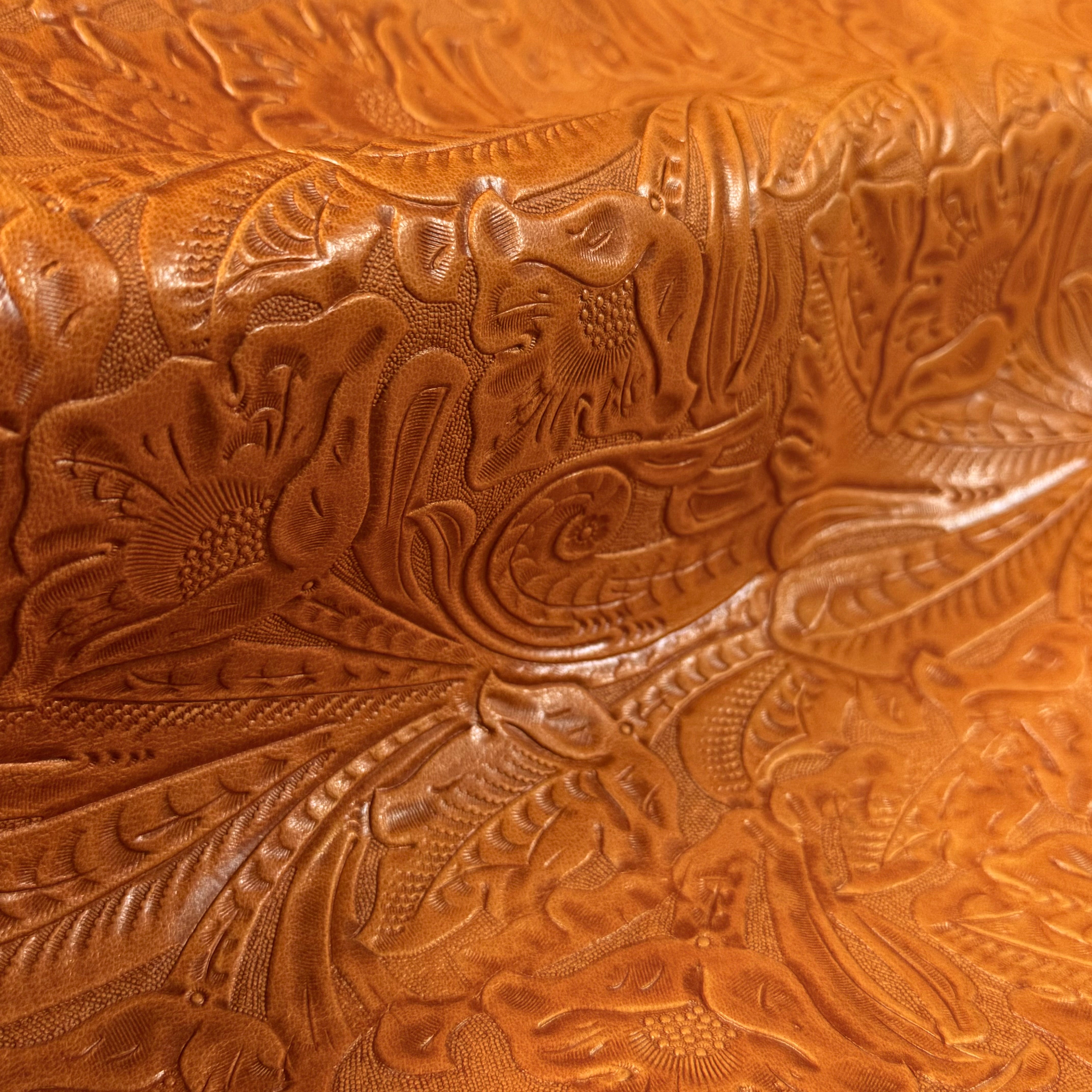 Close-up of brown floral embossed oiled veg tan lamb leather with a Sheridan pattern.