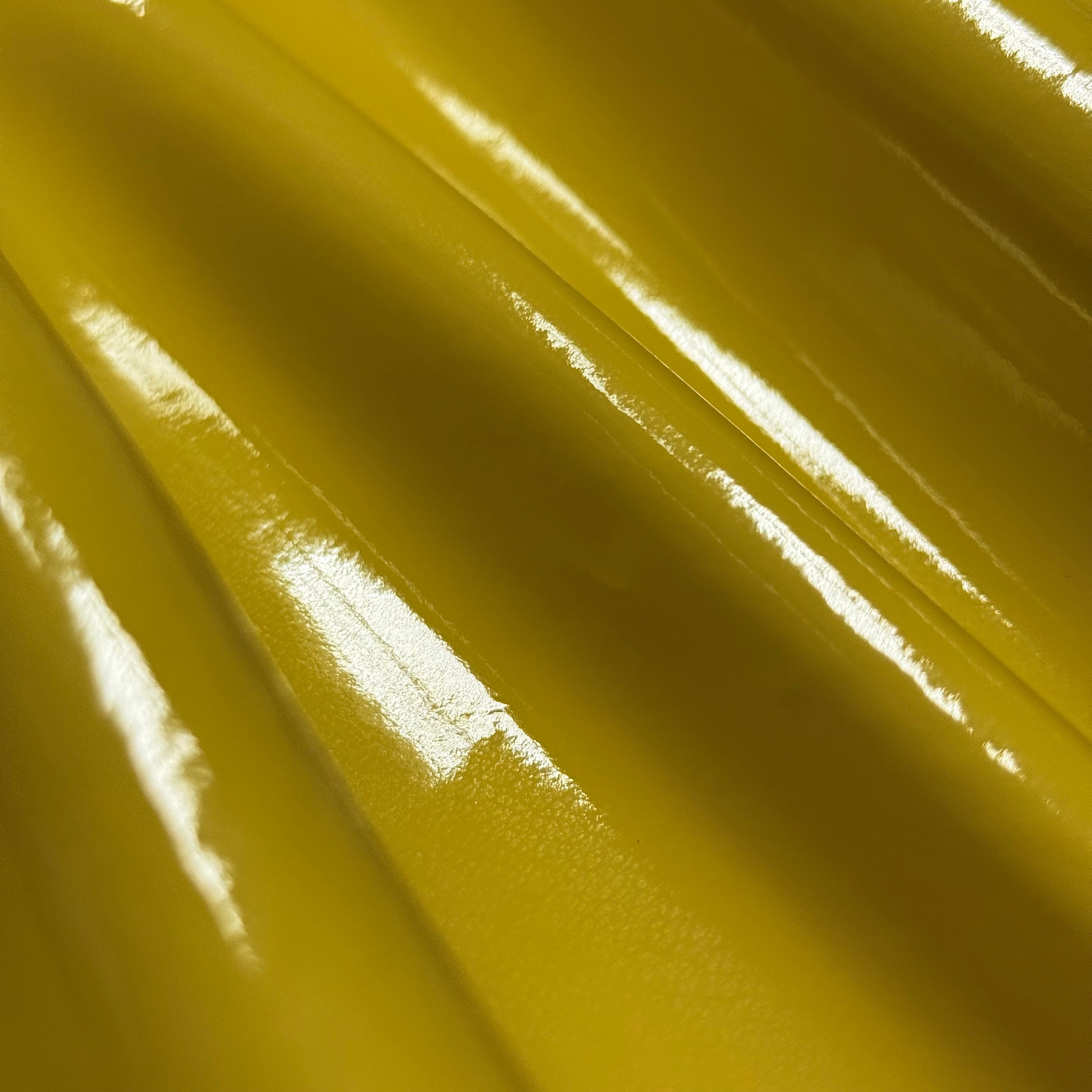 Patent Pig 1-2 oz leather in glossy mustard yellow with a smooth, reflective patent finish and soft folds.