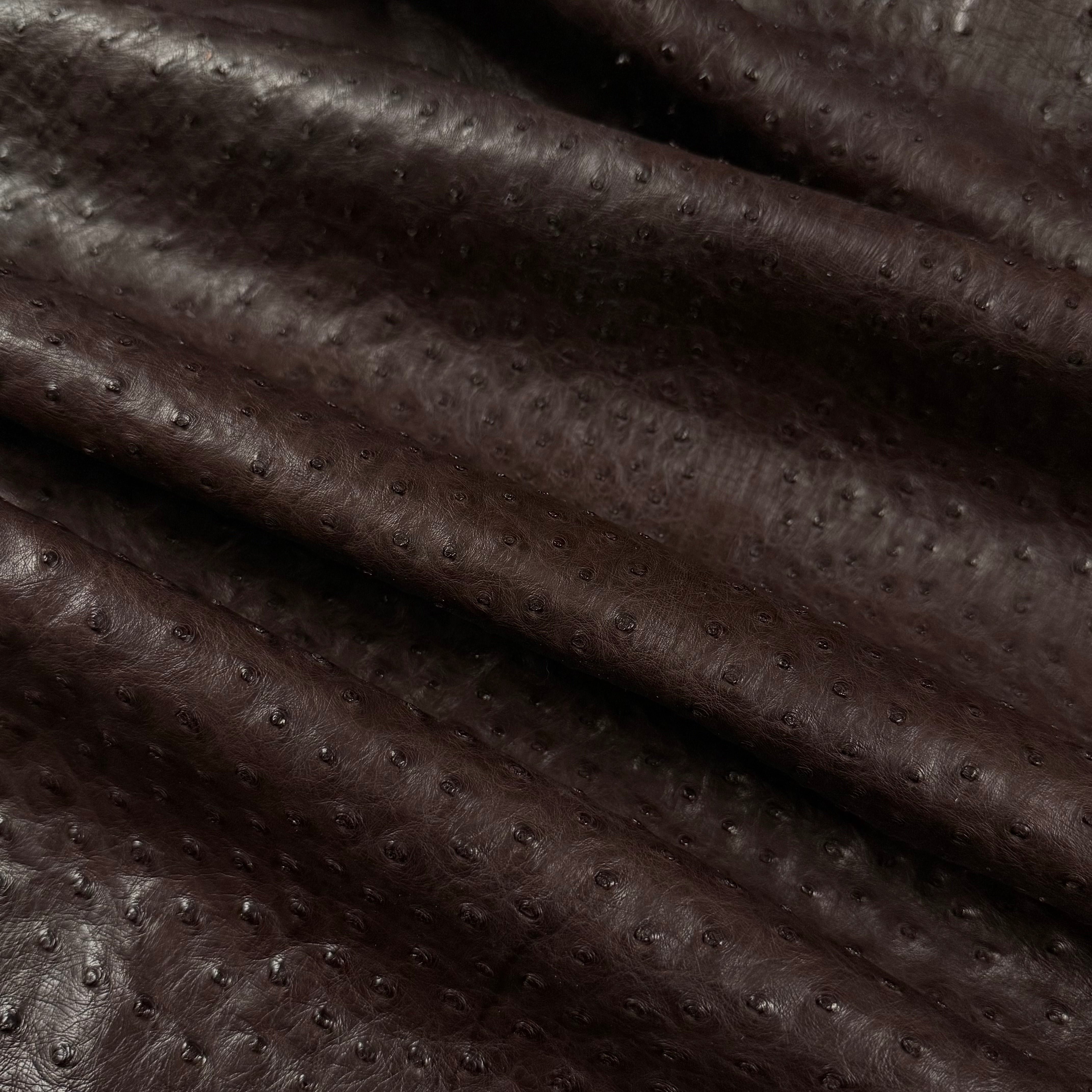 Dark brown full quill genuine ostrich leather with a natural, textured quill pattern and soft folds.