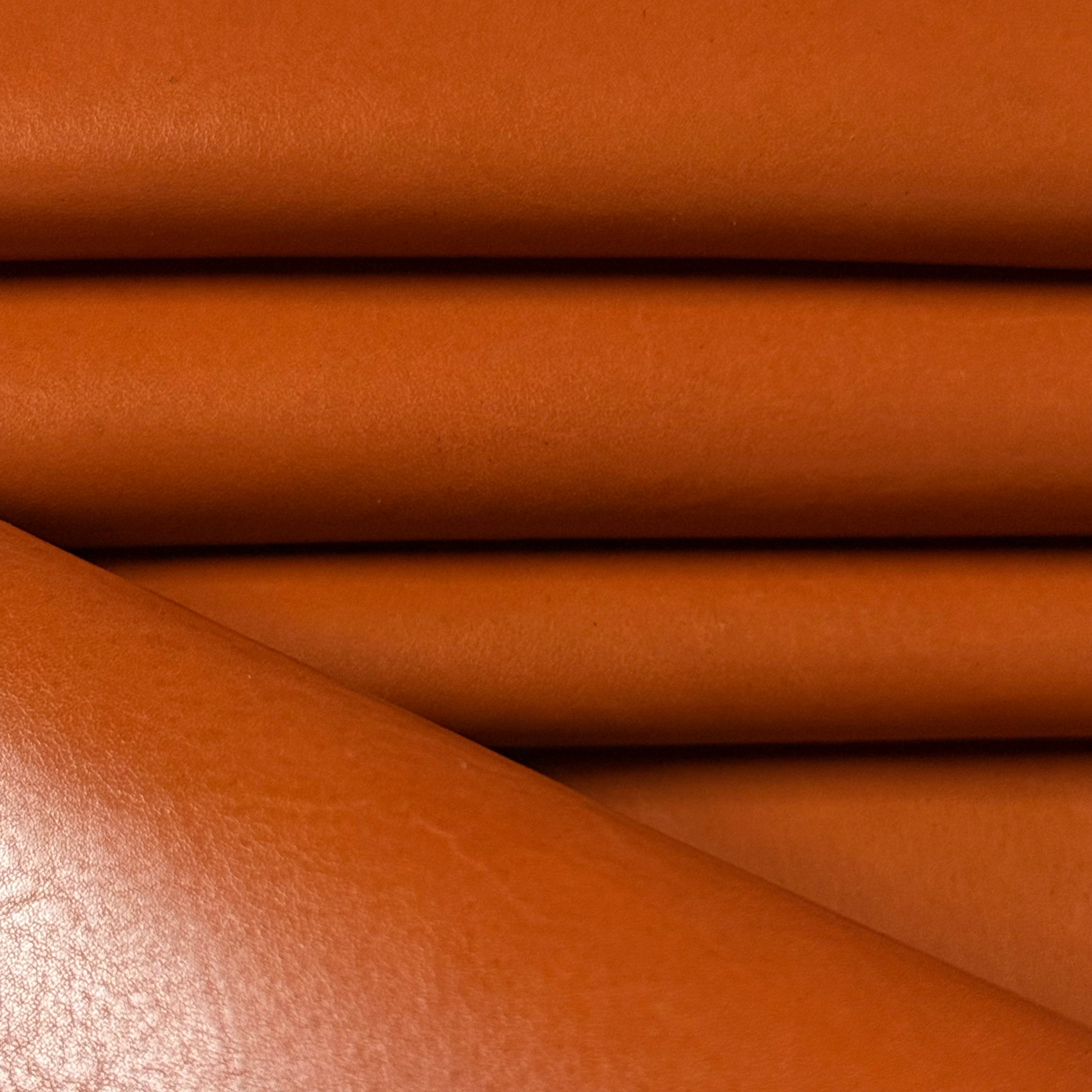 Smooth, polished orange vegetable-tanned baby calf leather, 2 oz, showing natural texture.
