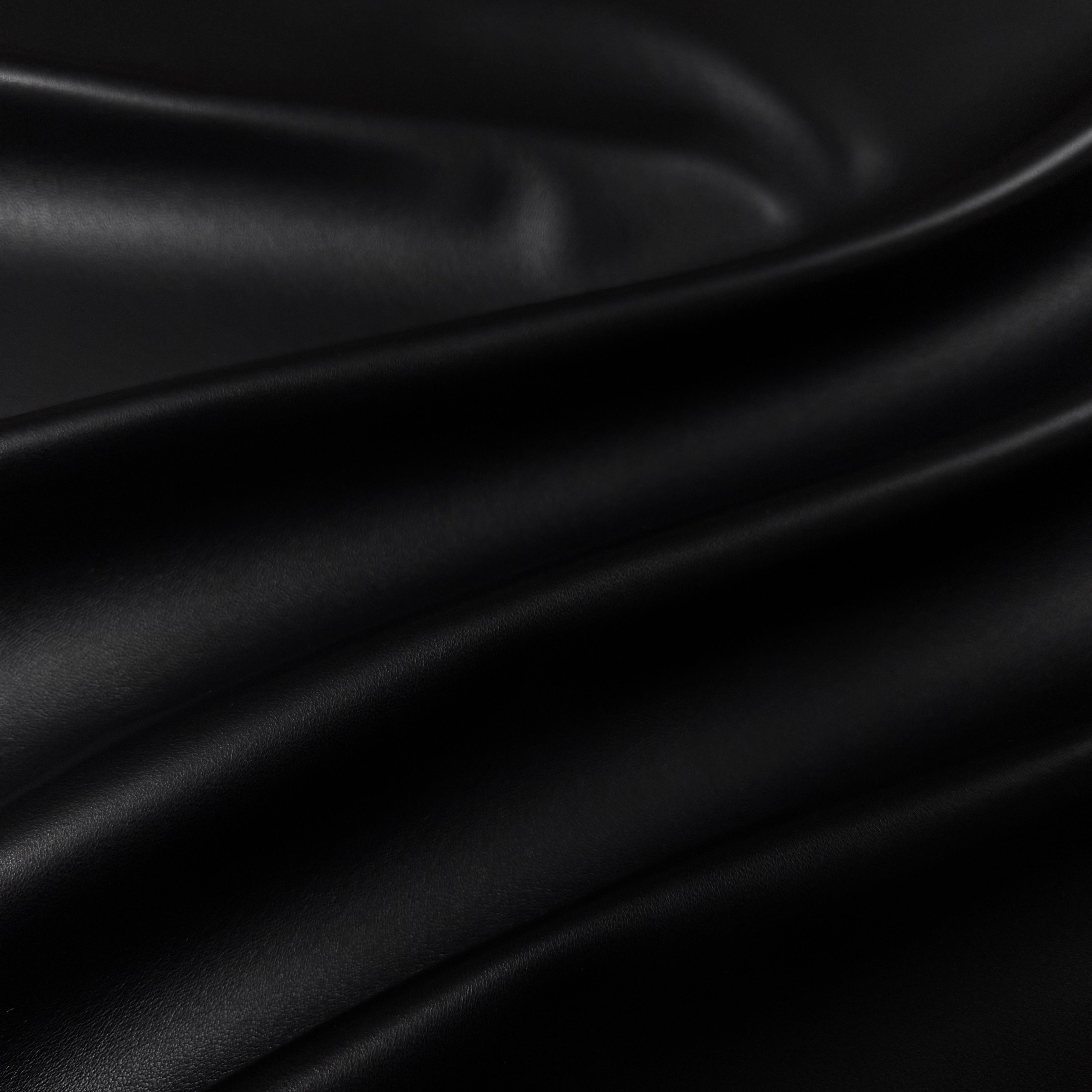 Draped black luxury aniline lamb nappa leather with a subtle sheen and smooth texture.