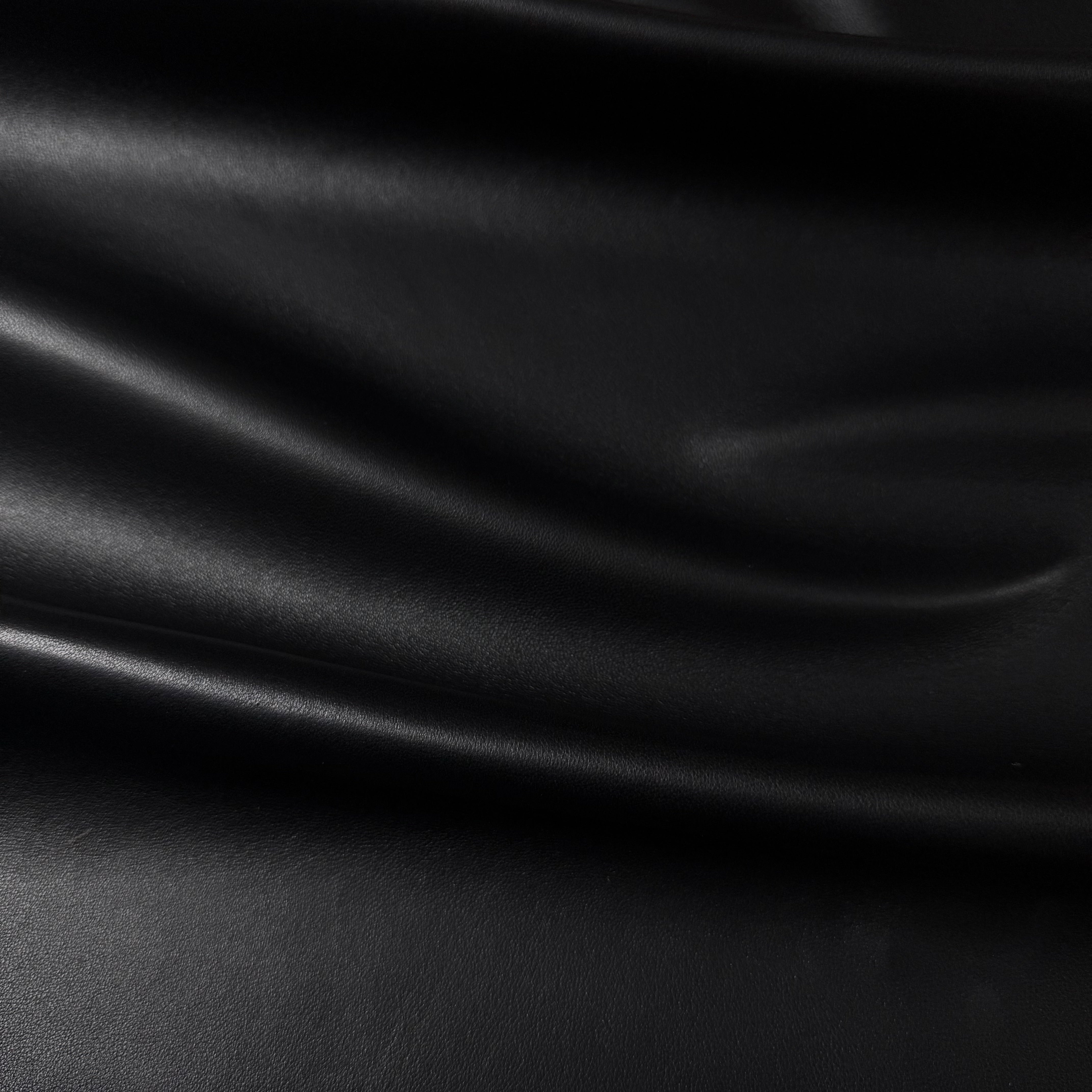 Draped black luxury aniline lamb nappa leather with a subtle sheen and smooth texture.