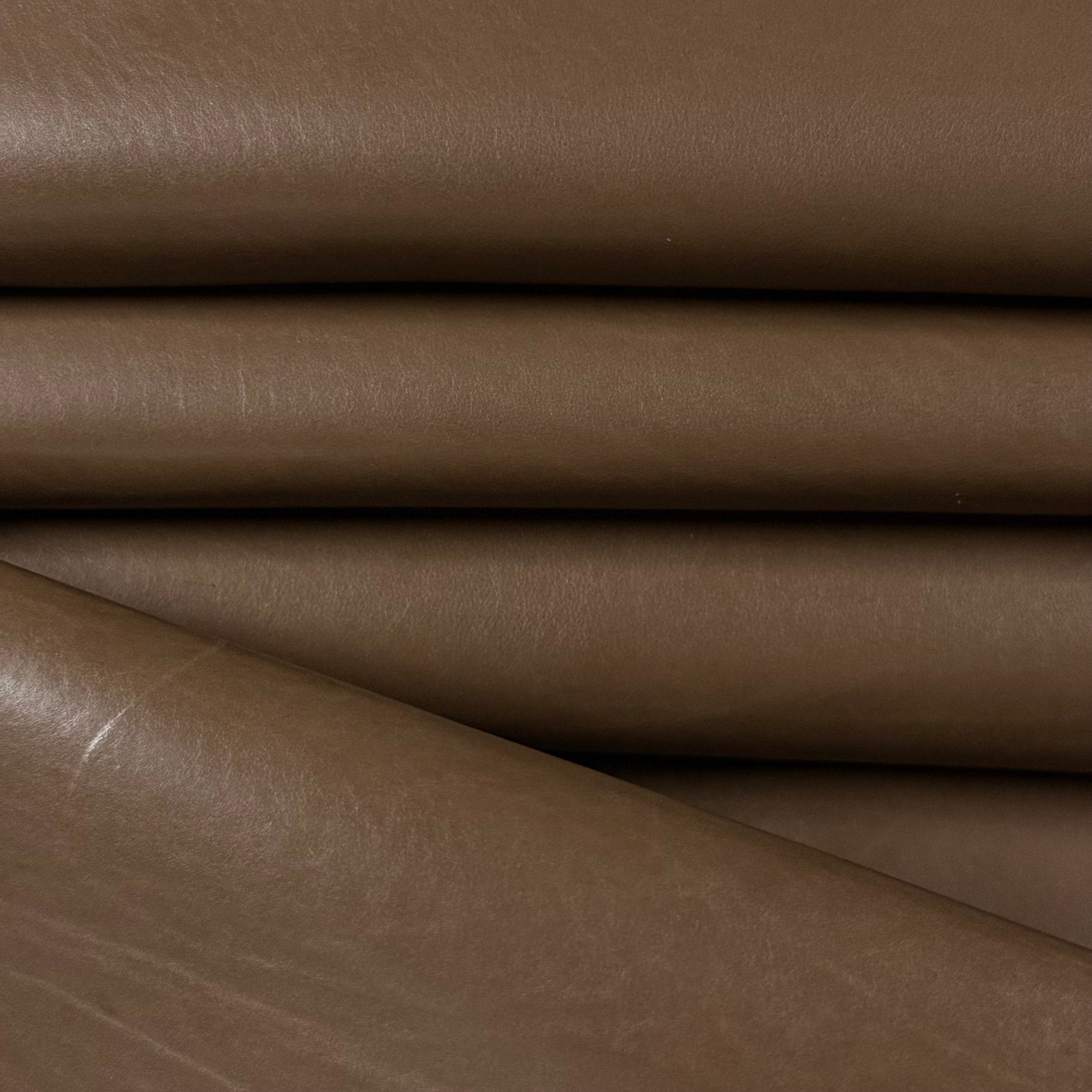 Smooth vegetable-tanned baby calf leather in a rich brown, showing its polished surface and natural texture.