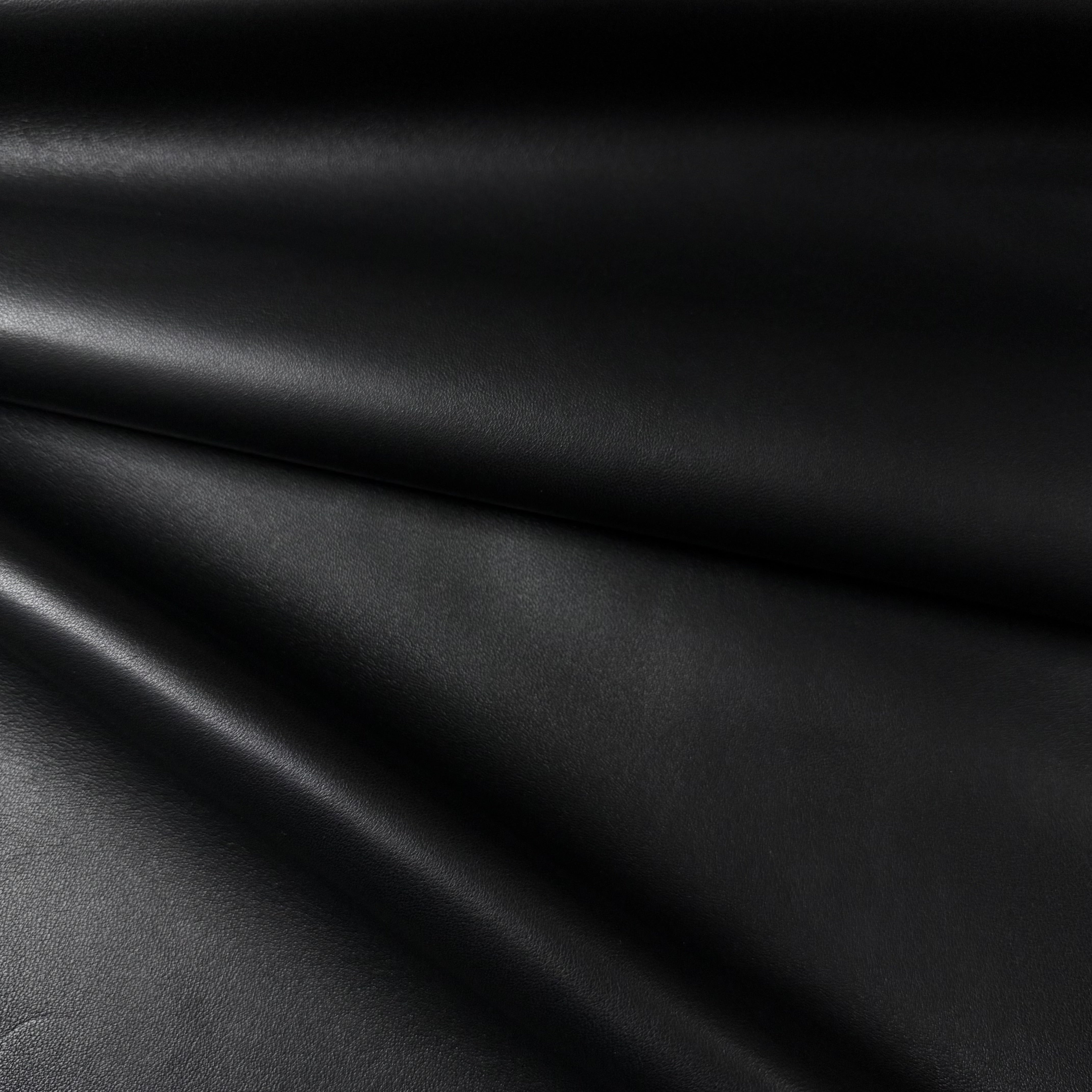 Black luxury aniline lamb nappa leather with a subtle sheen and smooth, drapey texture.