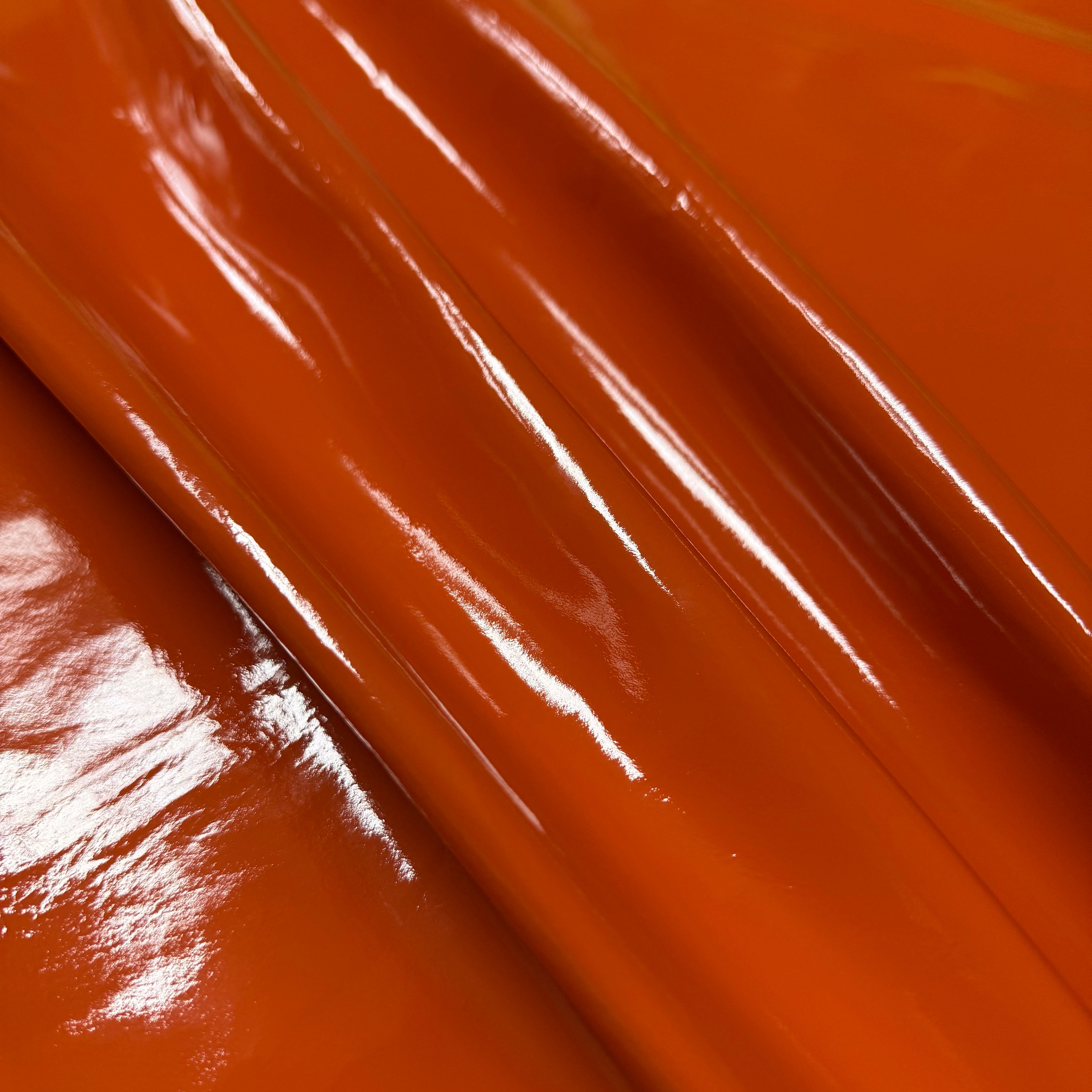 Patent Pig leather in vibrant orange, 1-2 oz weight with a high-gloss, reflective patent finish.