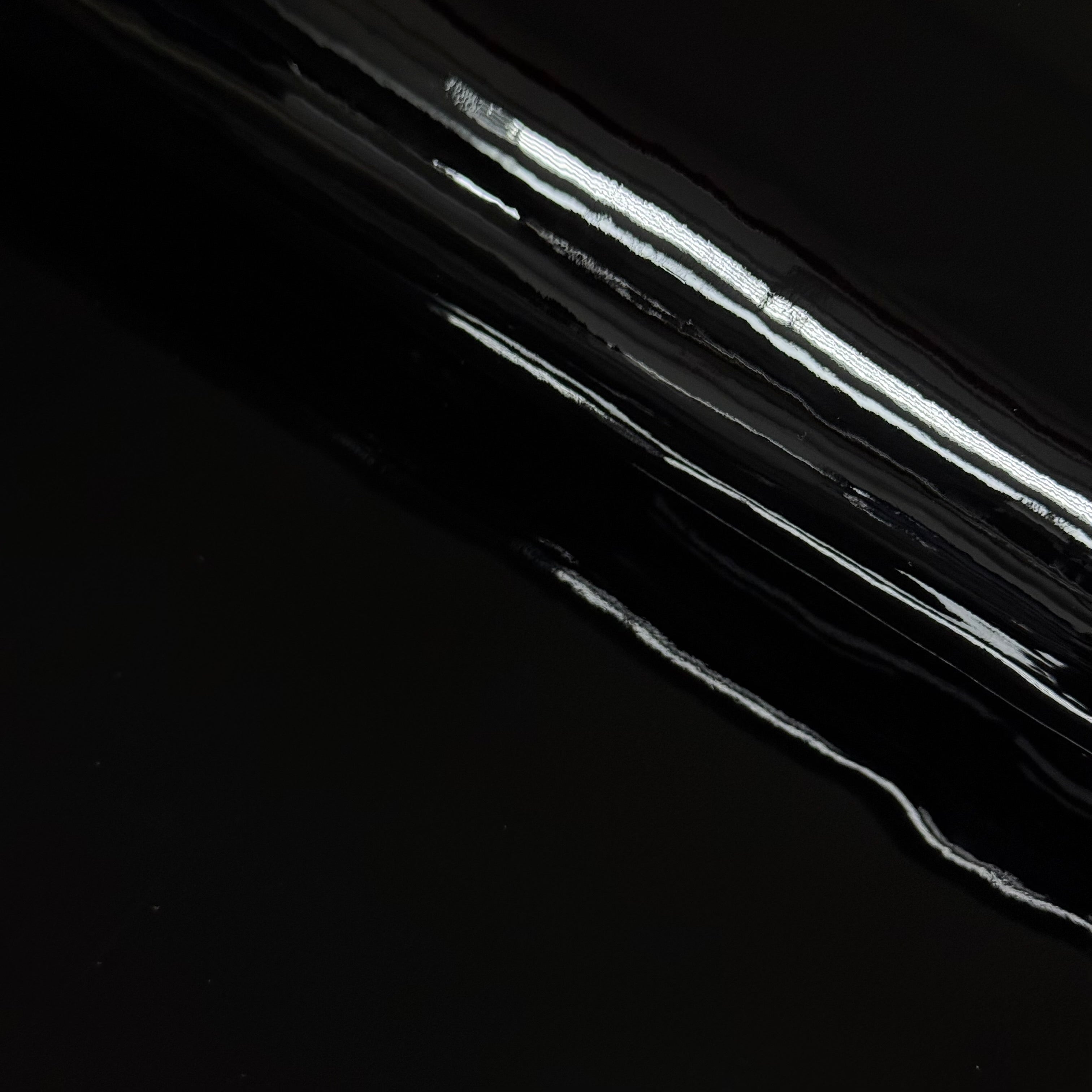 Black luxury patent cow leather with a glossy lacquer finish and reflective surface.