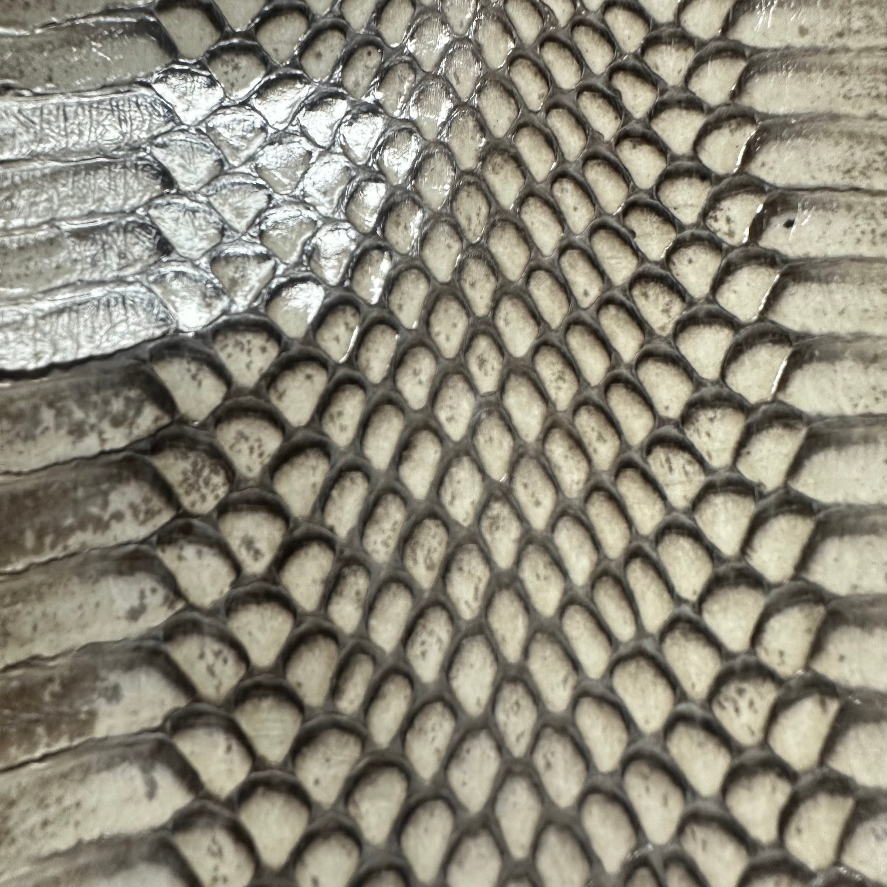 Cobra snake skin leather in a natural grey and white scale pattern with a glossy, textured finish.