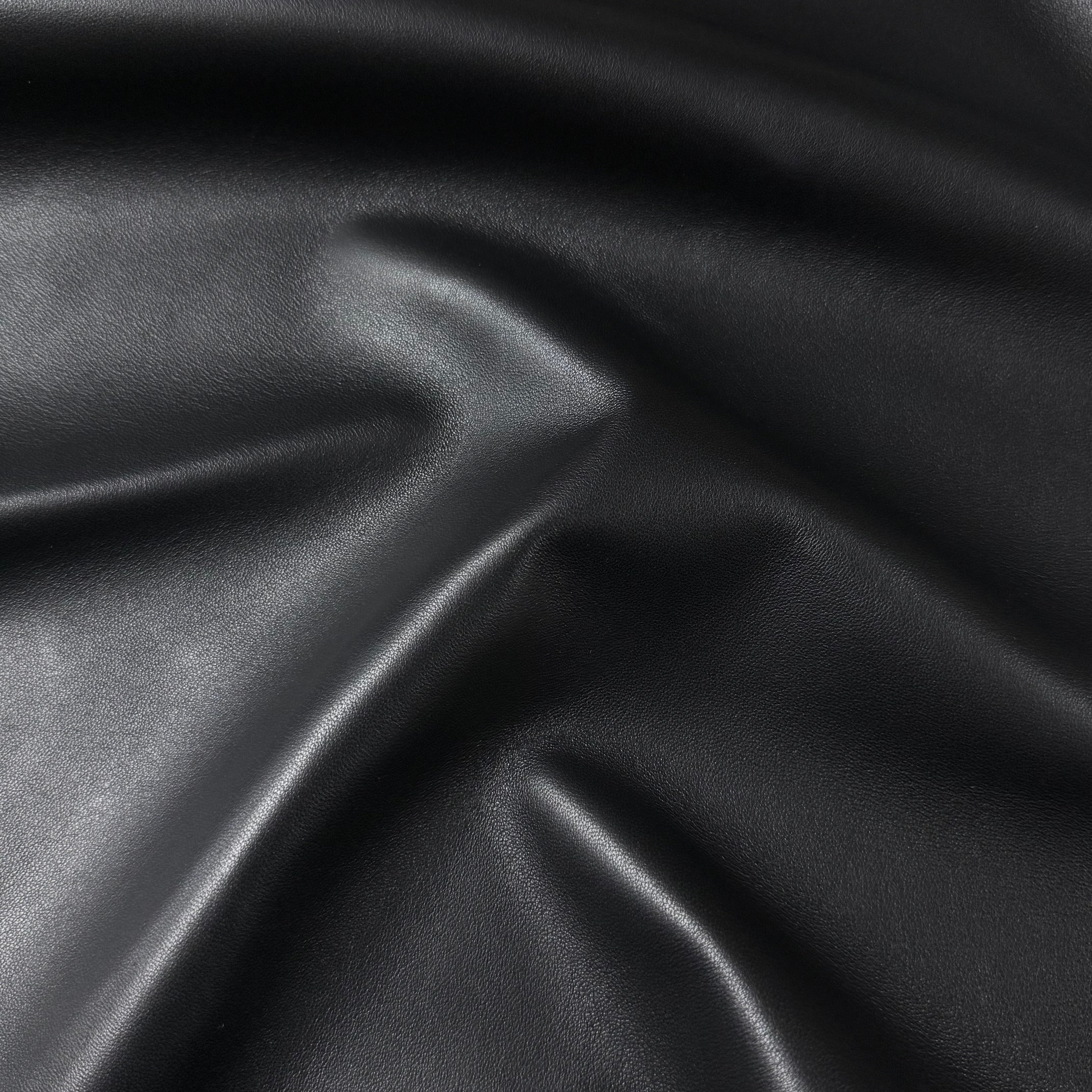 Wrinkled black aniline lamb nappa leather with a subtle sheen and smooth texture.