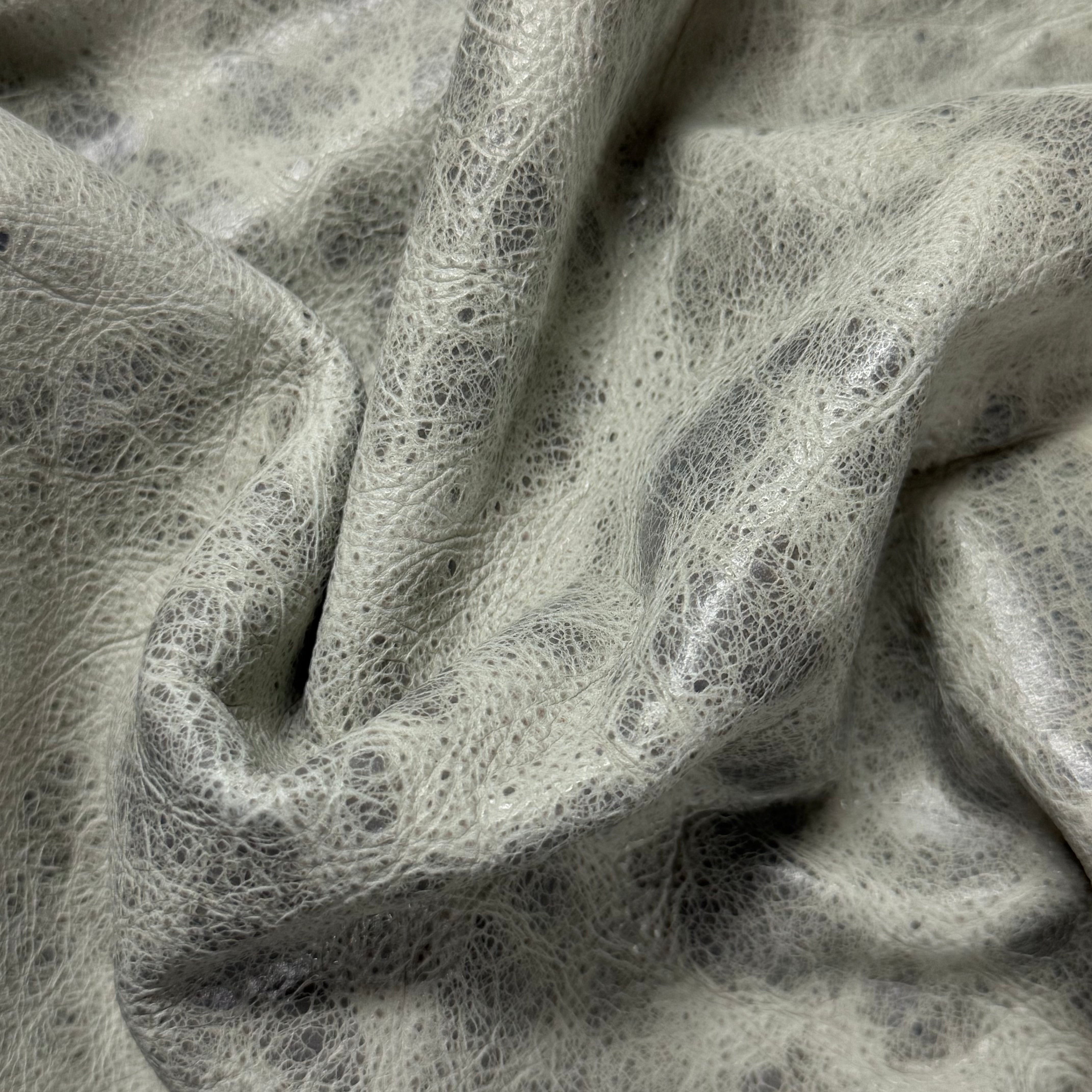 Light gray Carnauba Waxed Pull-Up Cowhide, 2-3 oz leather with a distressed, textured finish and natural folds.
