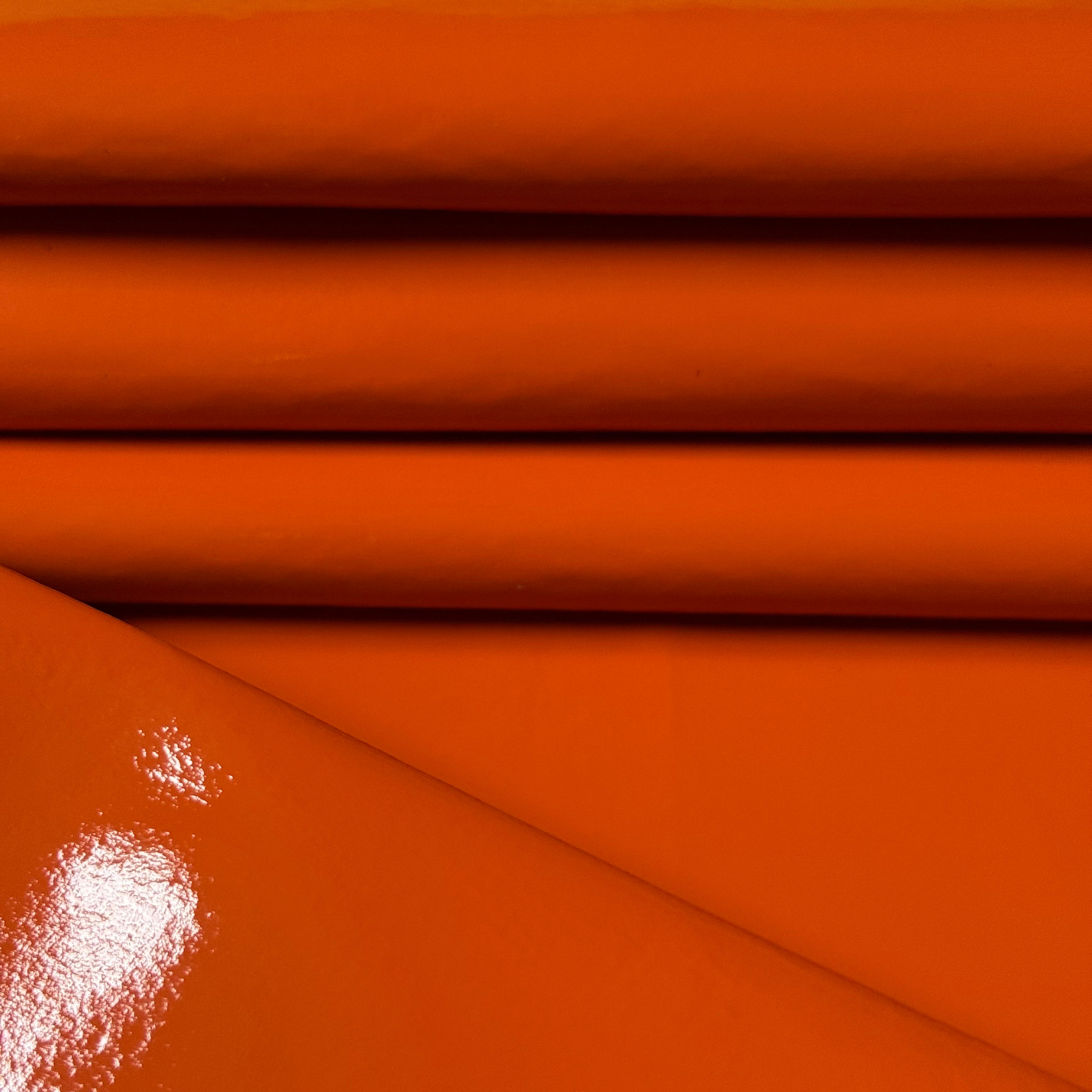 Patent Pig orange leather, 1-2 oz weight, featuring a smooth, high-gloss patent finish with reflective surface.