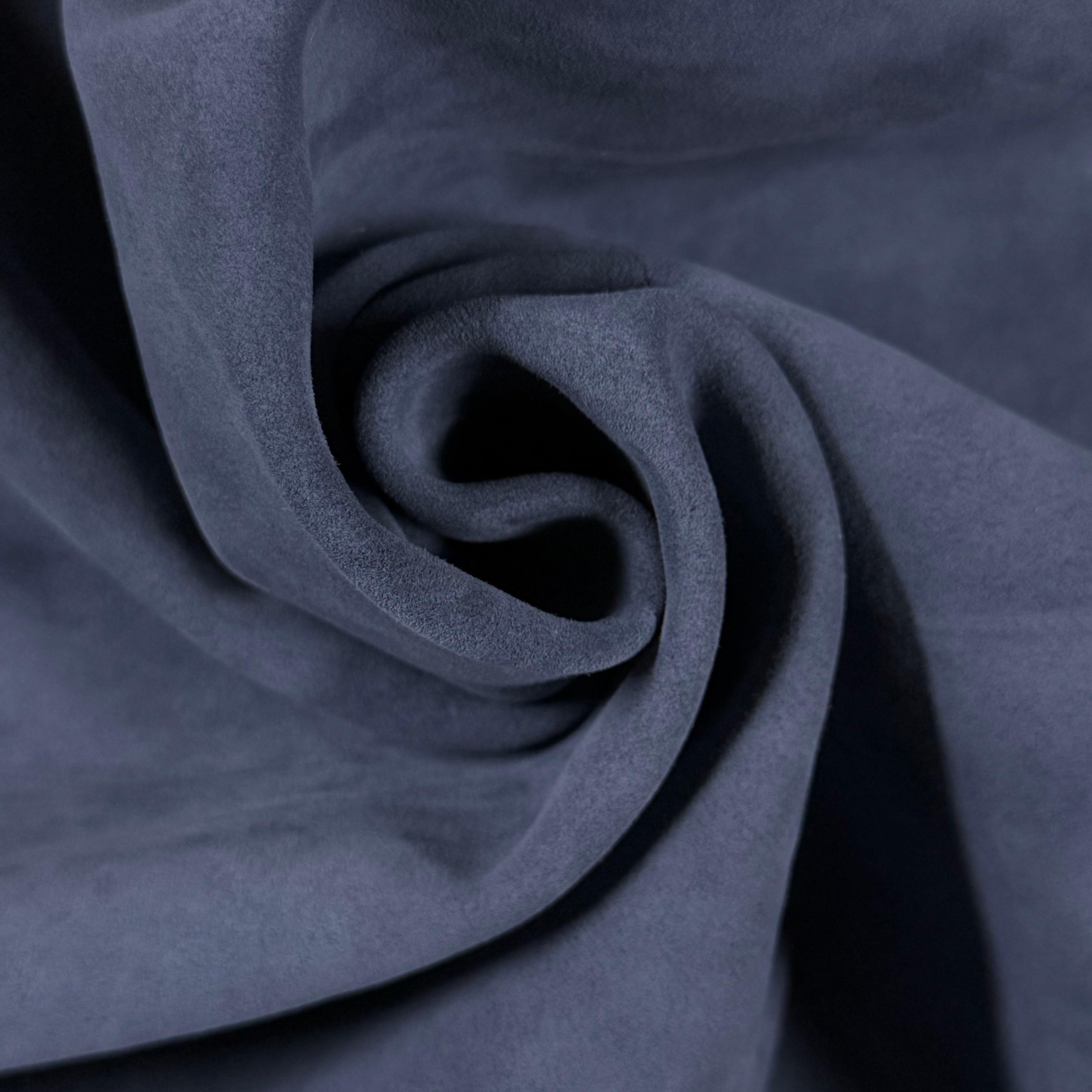 Close-up of soft, dark blue Conceria Incas Italian Water Calf leather with a suede-like finish, draped in gentle folds.