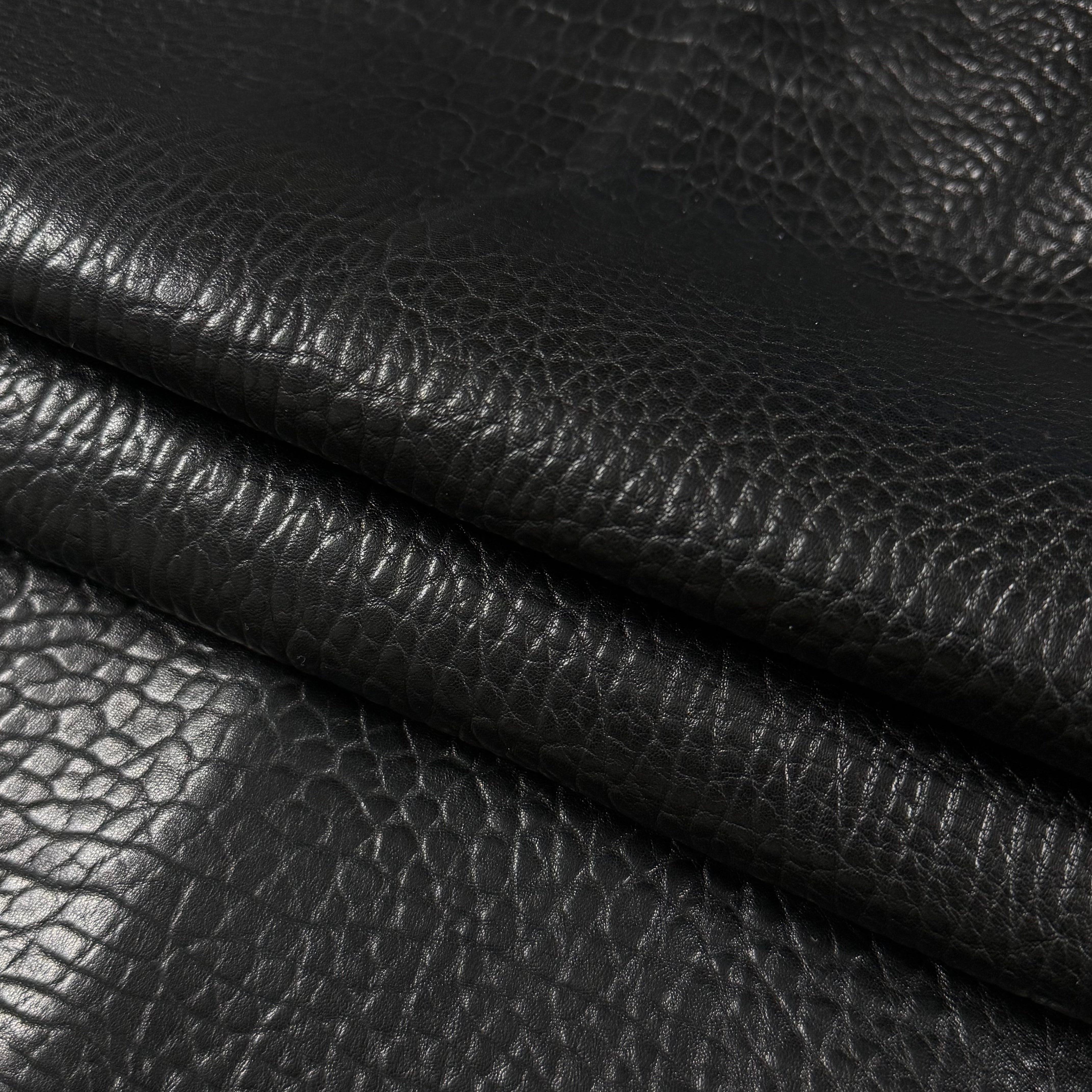 Black Shrunken Bubble Grain Veg Tan Lamb leather with a soft, textured surface and natural folds.