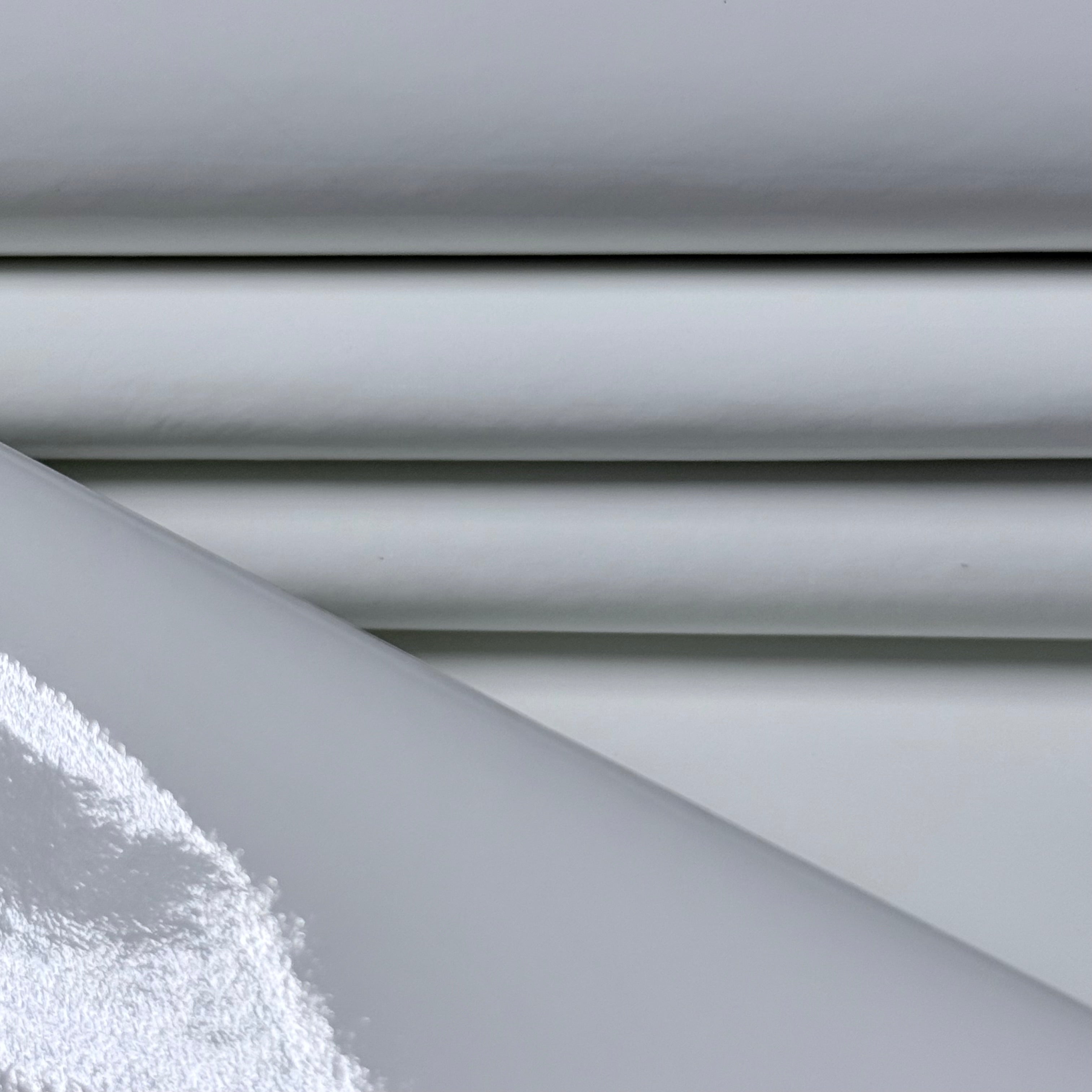 Patent Pig 1-2 oz leather in white with a high-gloss, reflective patent finish and smooth, folded texture.