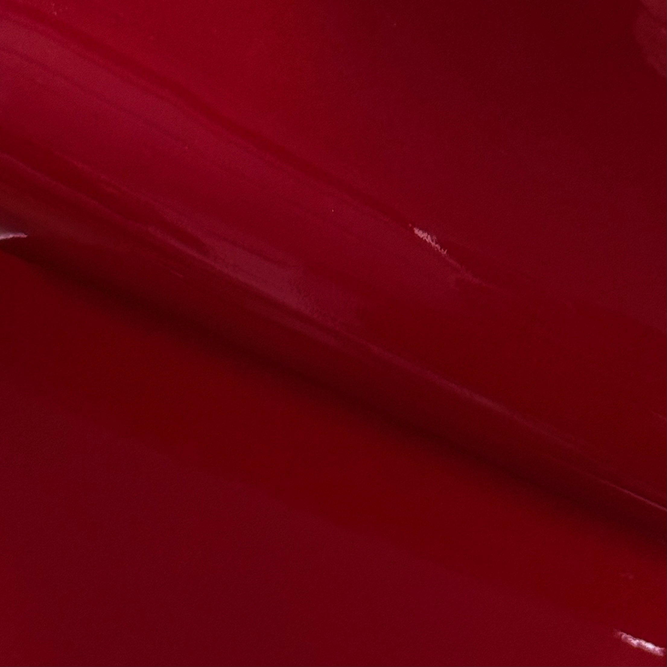 Smooth, glossy red patent cow leather with a reflective lacquer finish.