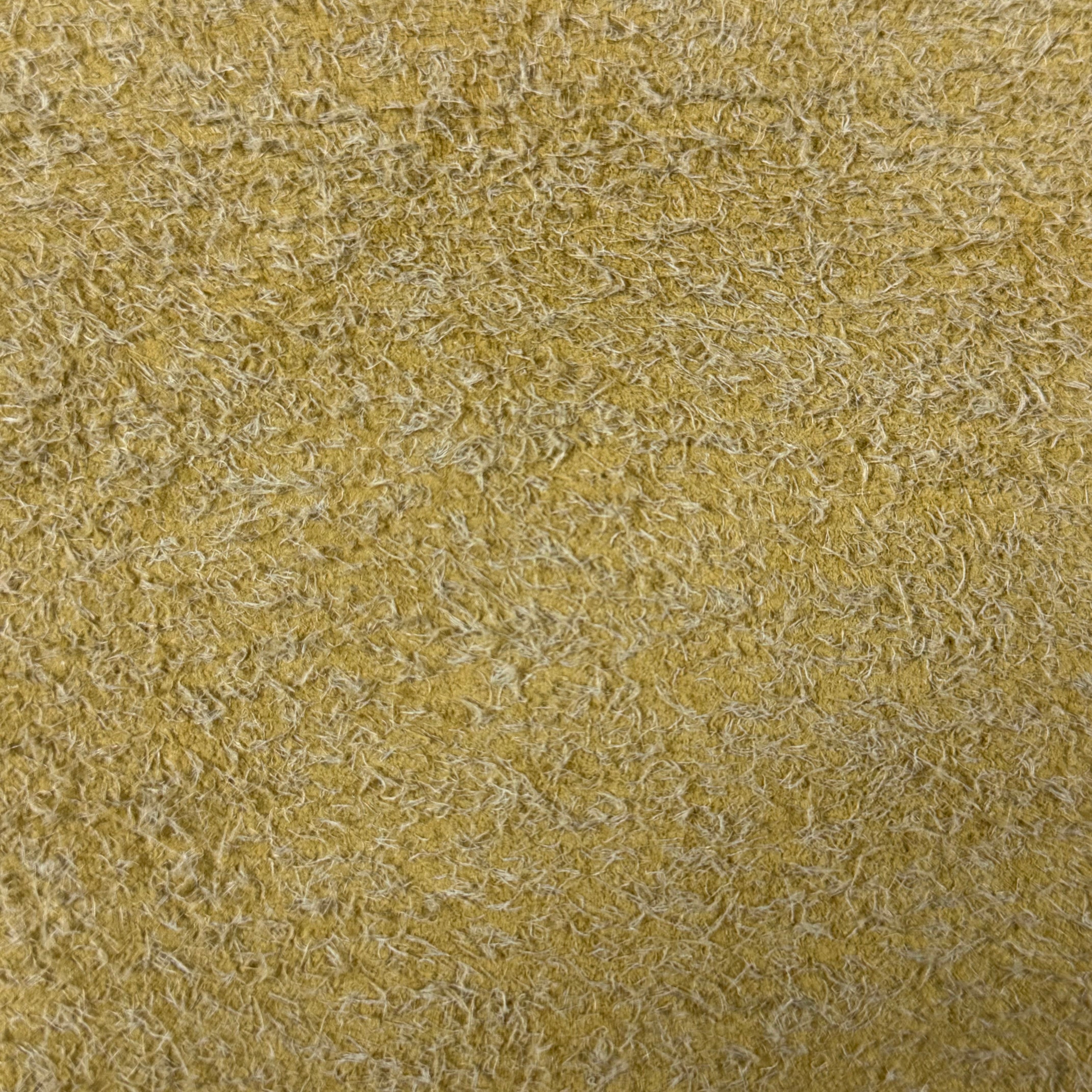 Close-up of a yellow hairy calf suede leather bend with contrasting long, shaggy fibers.