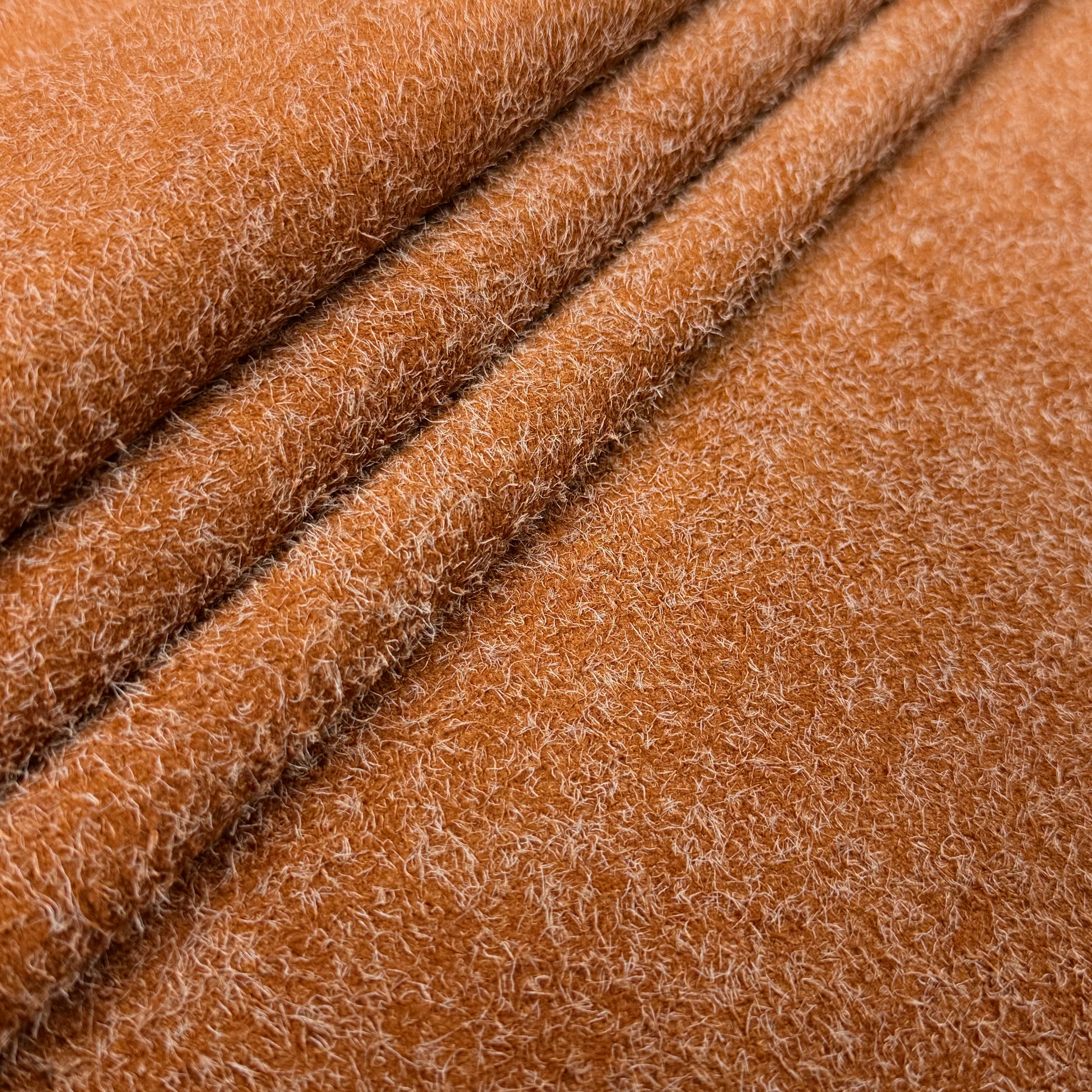Close-up of a folded Hairy Calf Suede Bend in a warm brown color, showing its shaggy, textured surface.