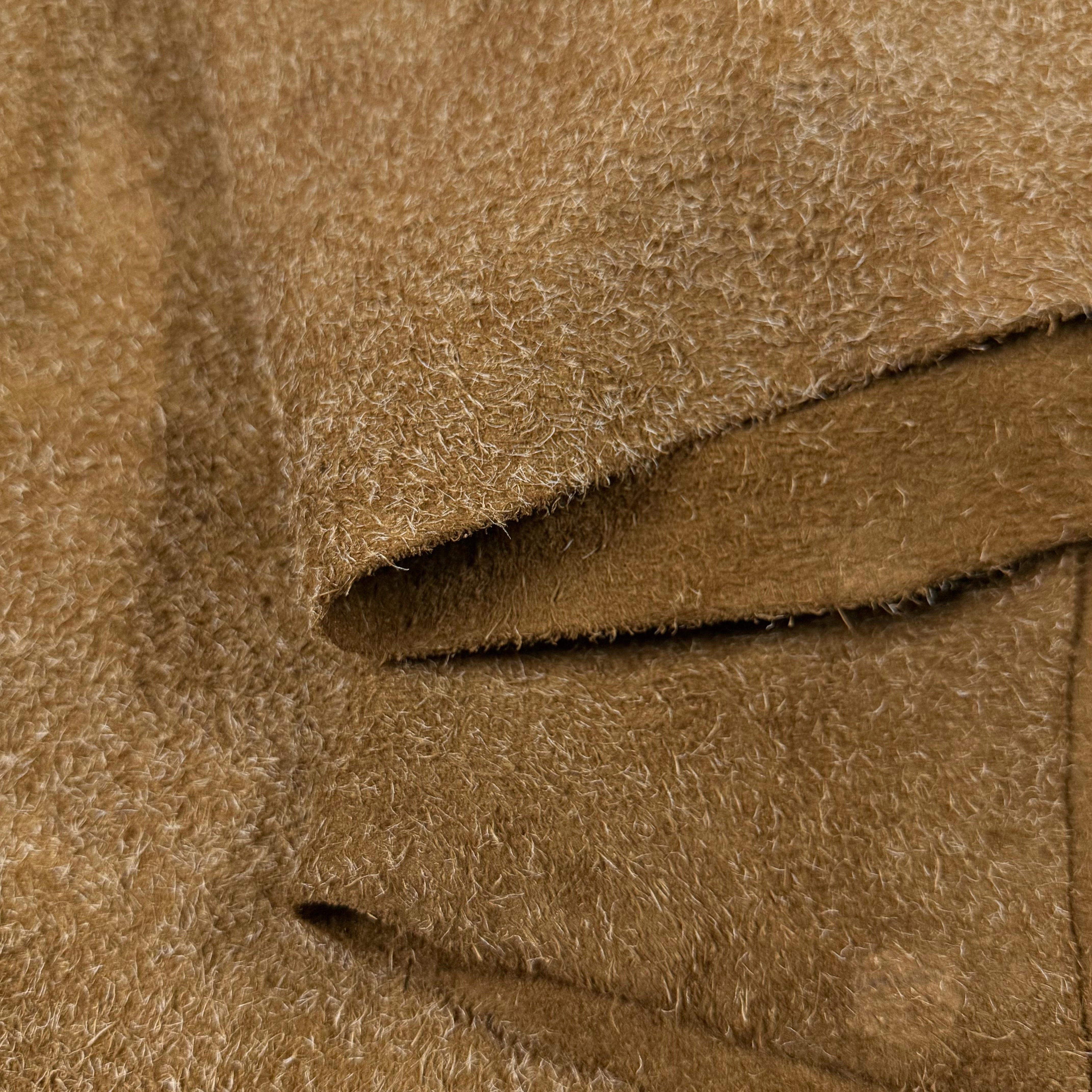 Close-up of a tan hairy calf suede bend with long, shaggy fibers and a rough-out texture.