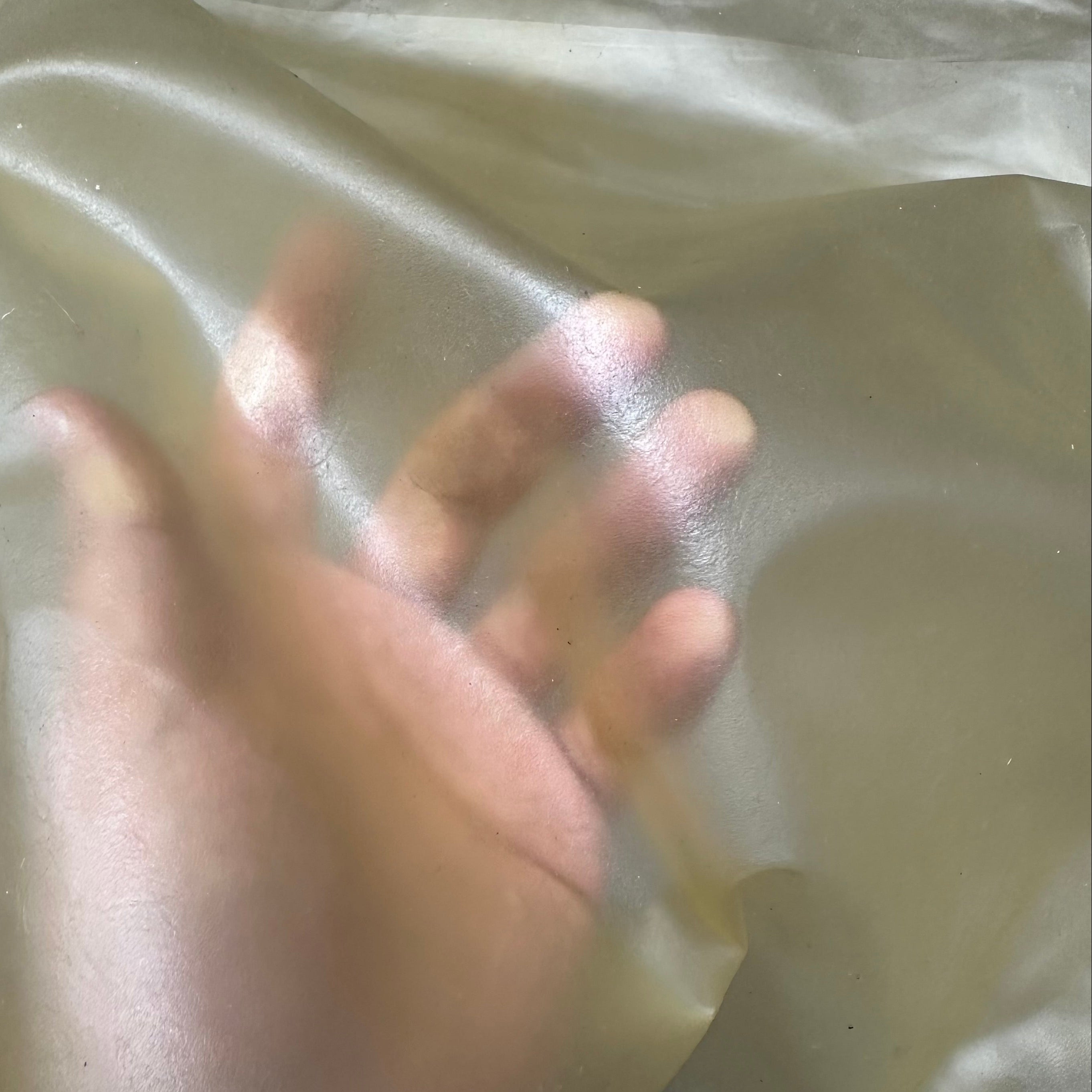 Transparent Lamb Leather in natural, a 1.5 oz lightweight, translucent material showing a hand underneath for scale.