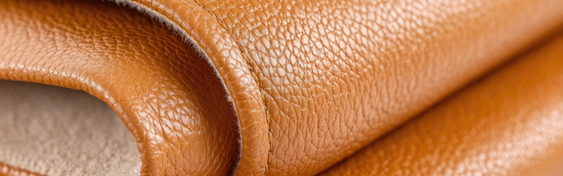 a closeup of a folded section of faux leather with a pebble grain and caramel color