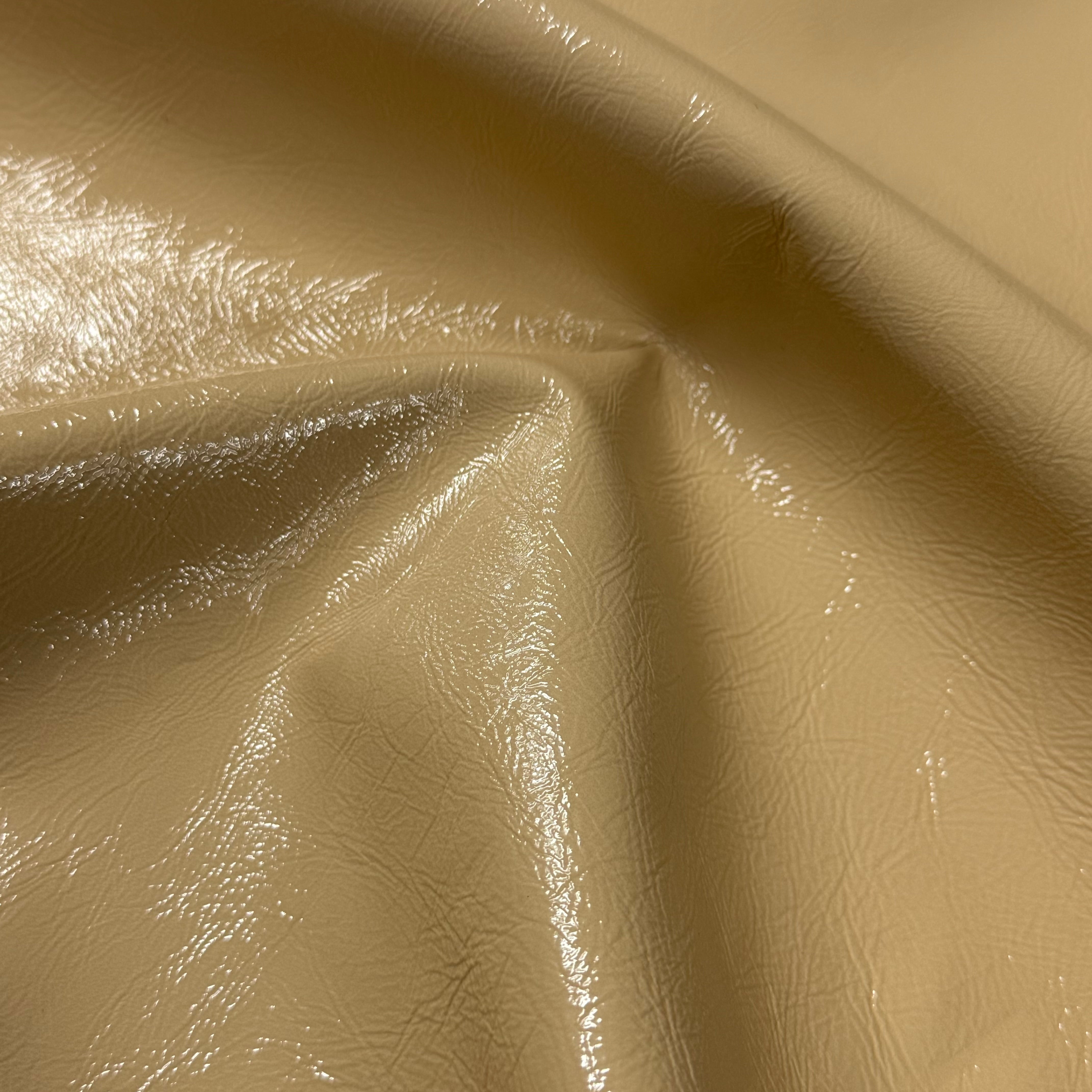 Beige distressed crinkle patent lamb leather with a glossy, textured surface and soft folds.