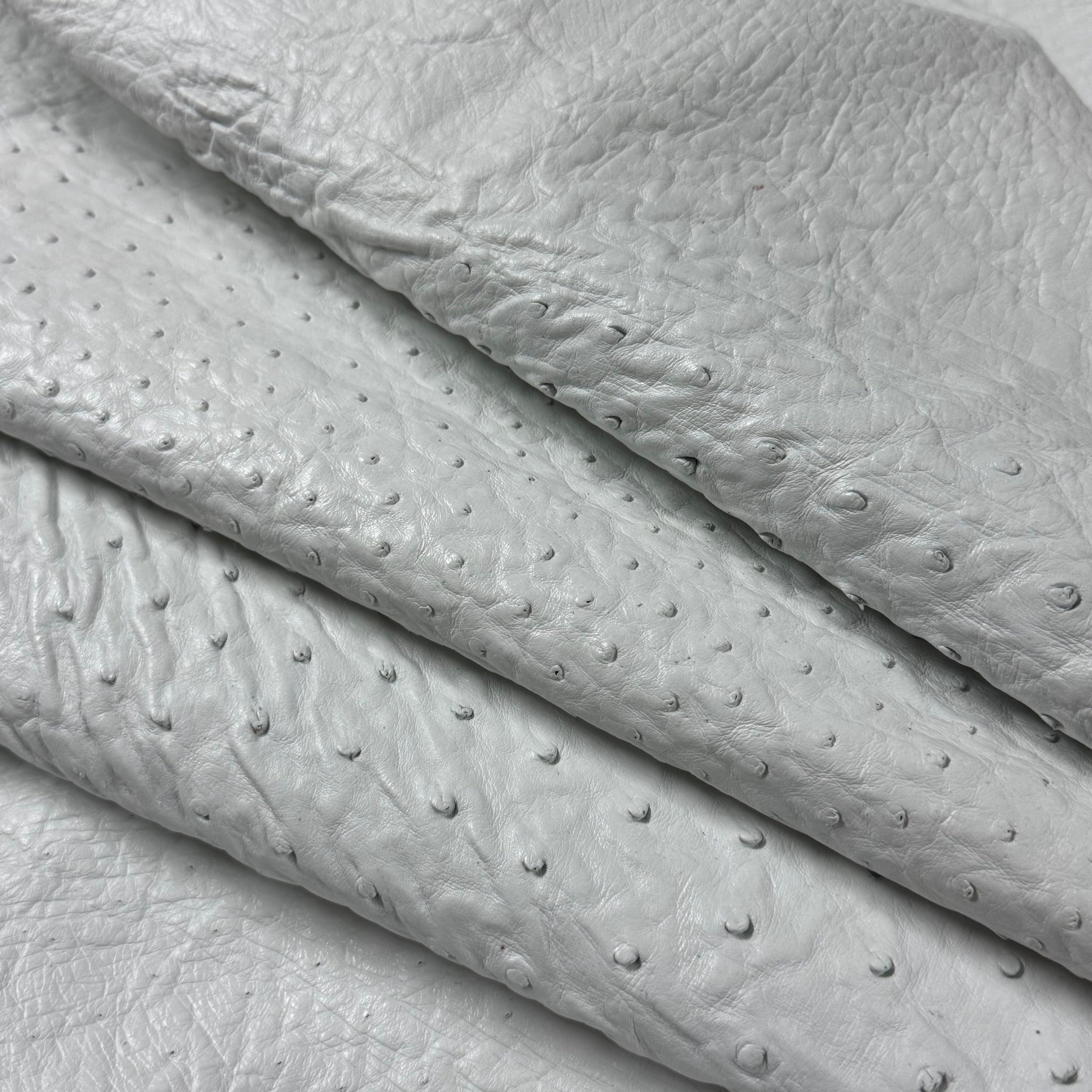 Folded white full quill genuine ostrich leather with natural raised quill pattern.