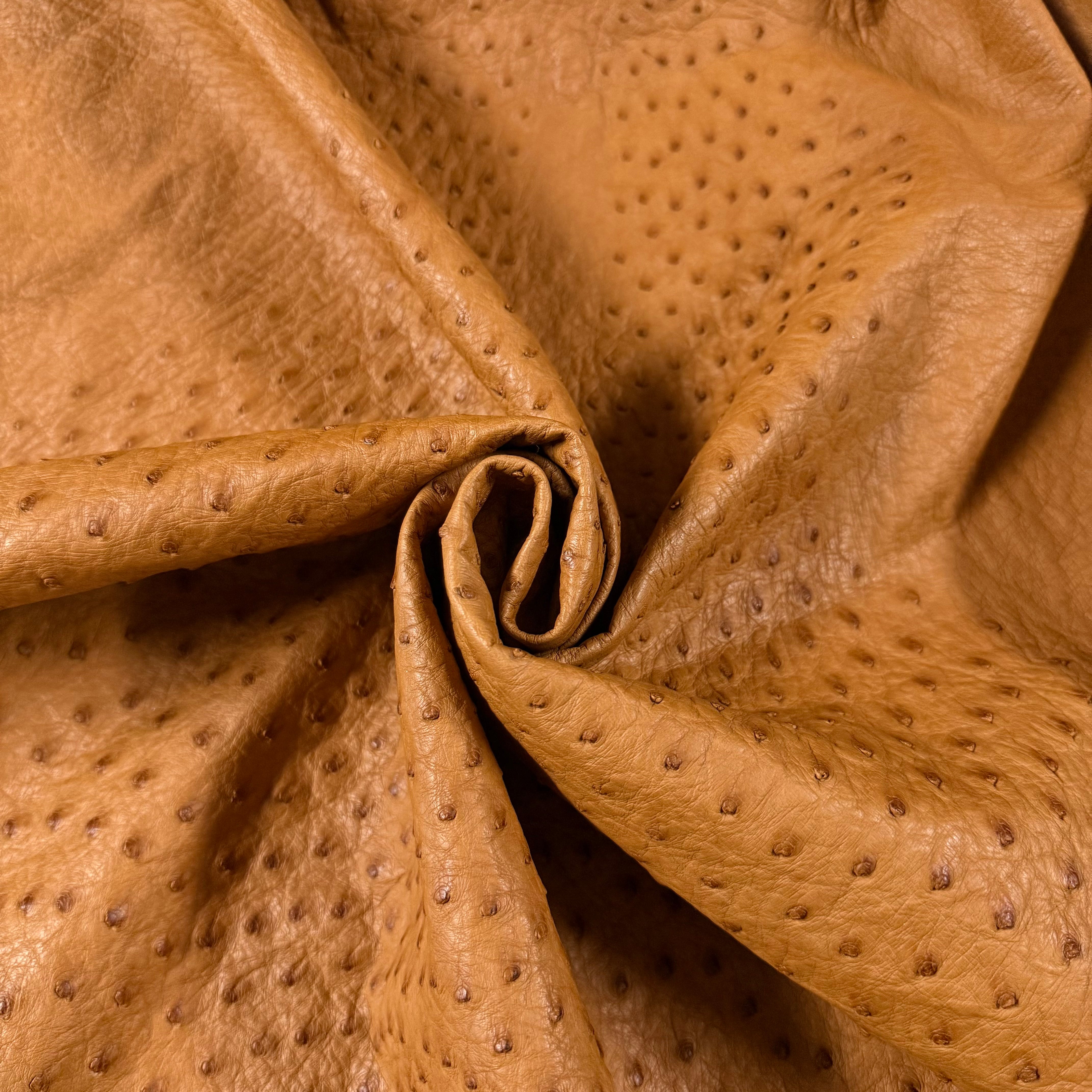 Tan full quill genuine ostrich leather with a distinctive raised quill pattern, soft temper.