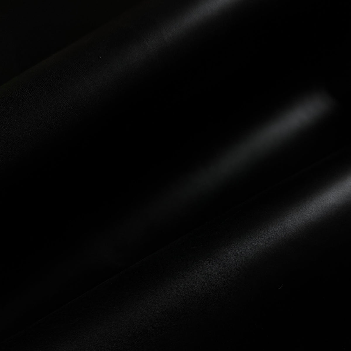 Apollo black leather fabric with a smooth, matte finish and elegant, soft folds creating subtle light reflections.