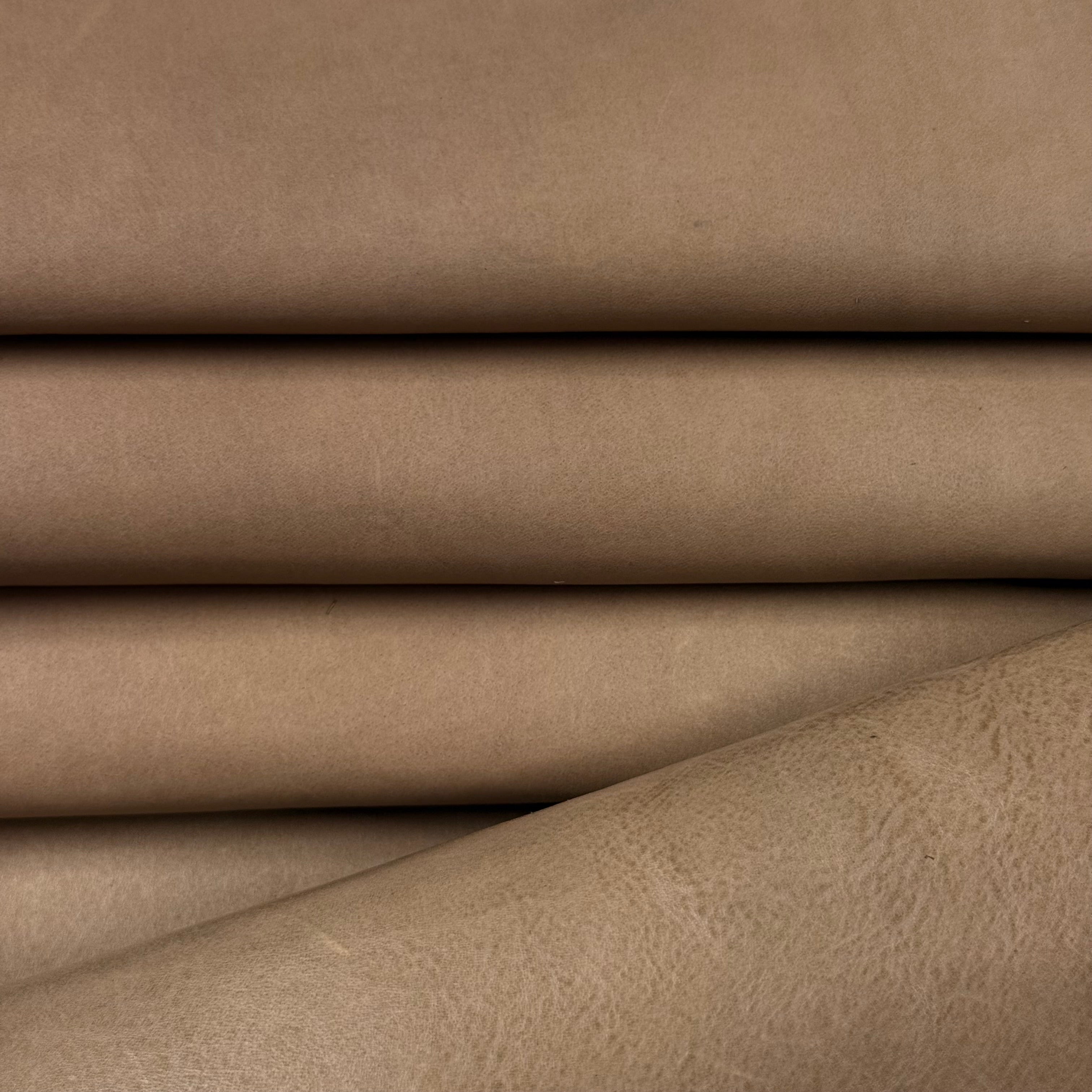 Smooth vegetable-tanned baby calf leather in a natural tan color, showcasing its polished surface and soft folds.