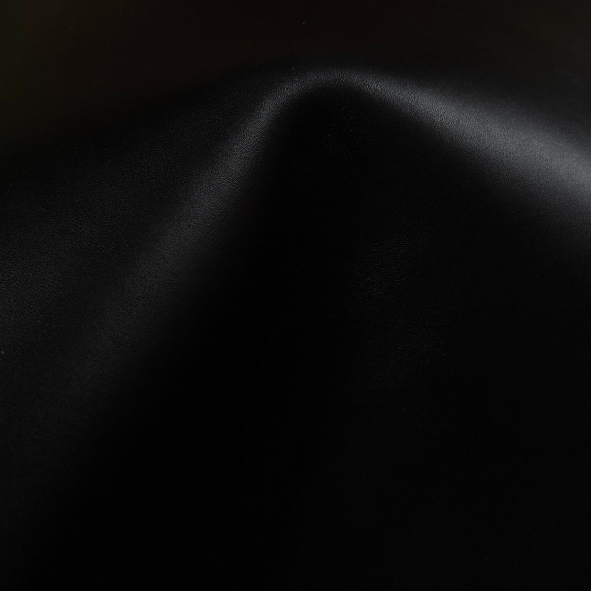 Apollo black leather material with a smooth, matte texture and soft, elegant folds.