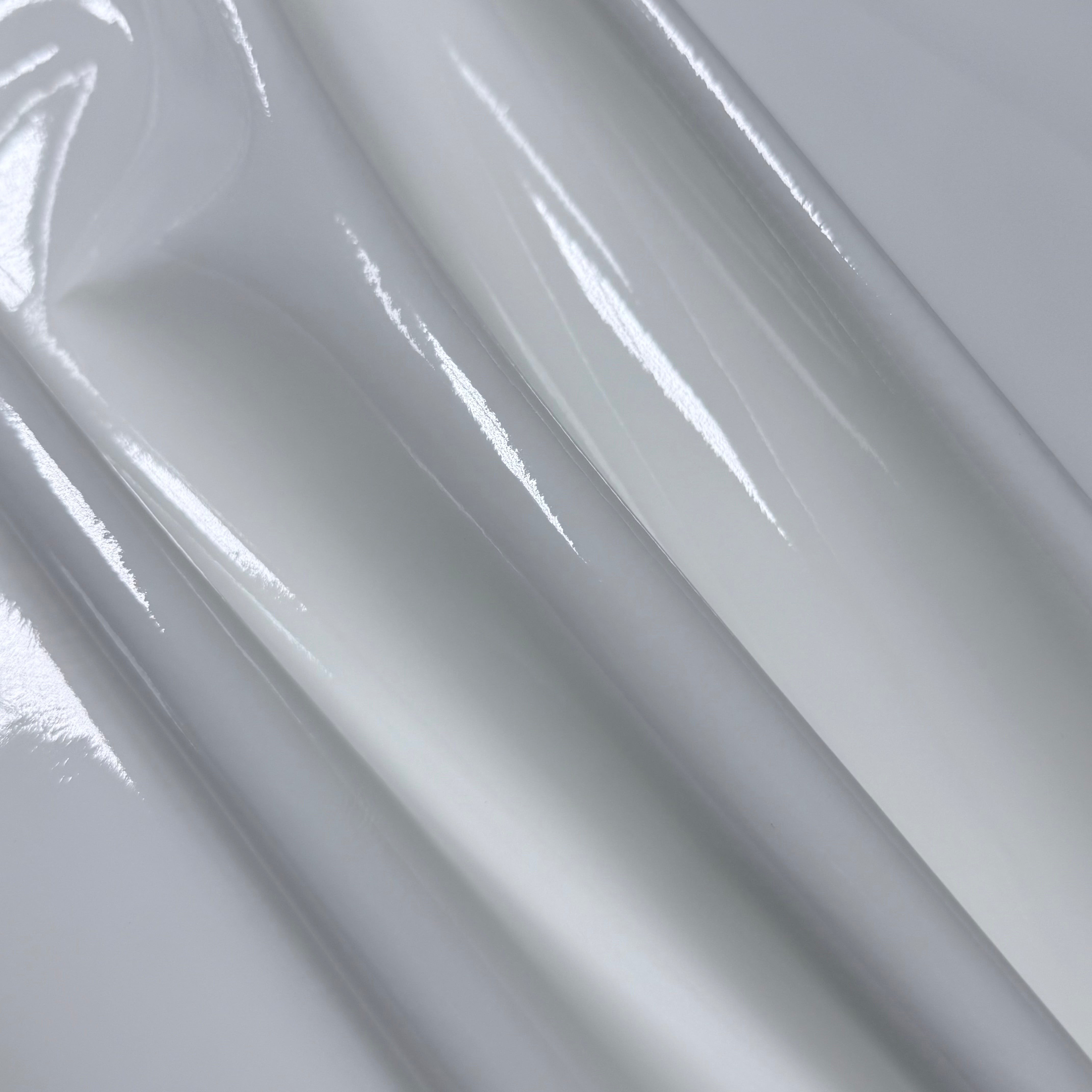 Patent Pig 1-2 oz white leather with a high-gloss, reflective patent finish and smooth, folded texture.