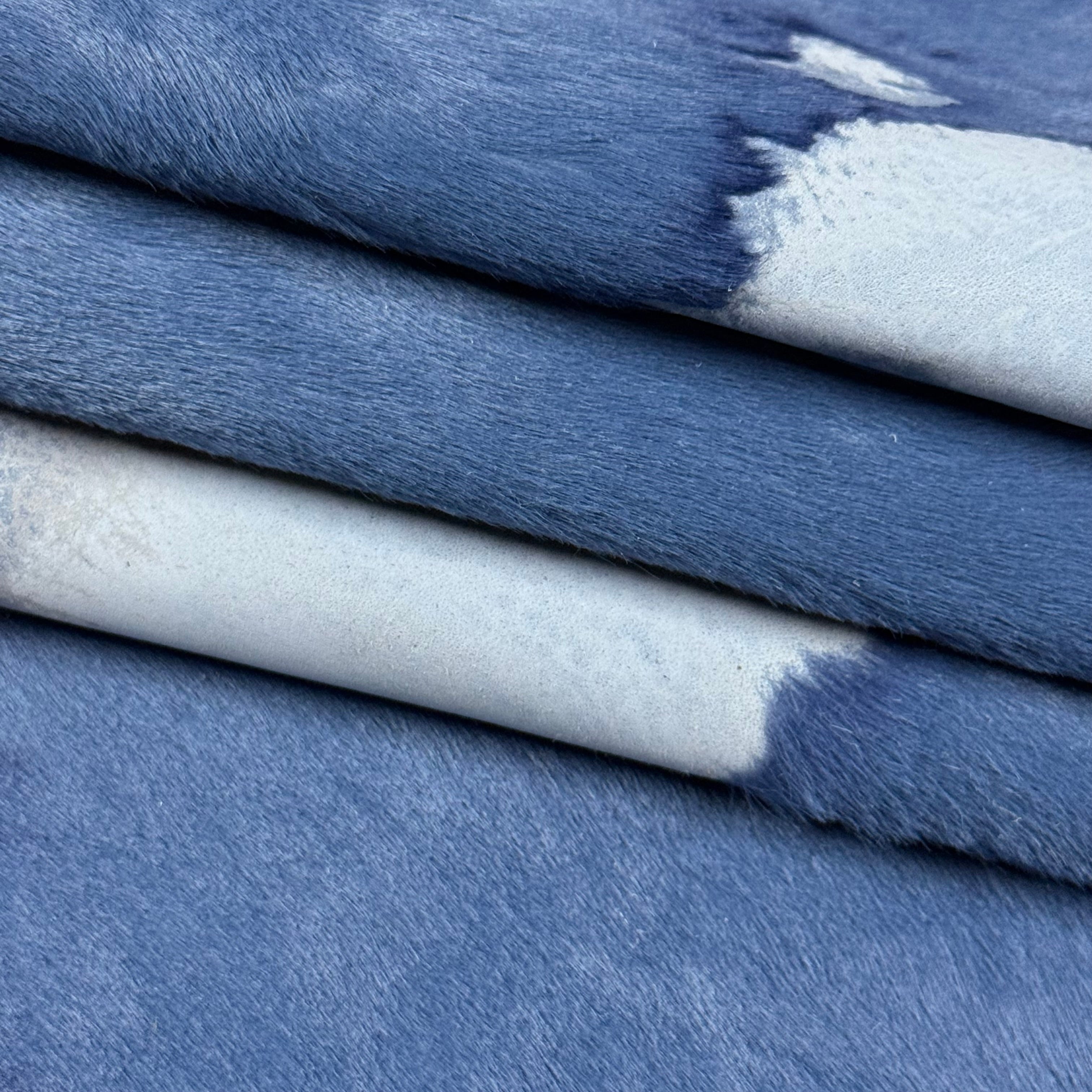 Blue acid wash Cavallino hair-on calf leather with two-tone burnout effect and natural spotting.