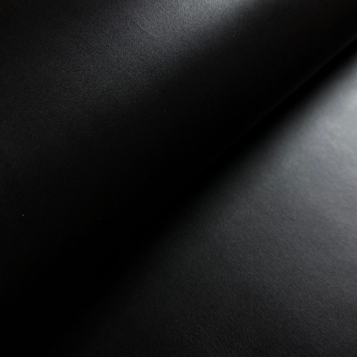 Apollo black leather material with a smooth, matte texture and elegant diagonal lighting.