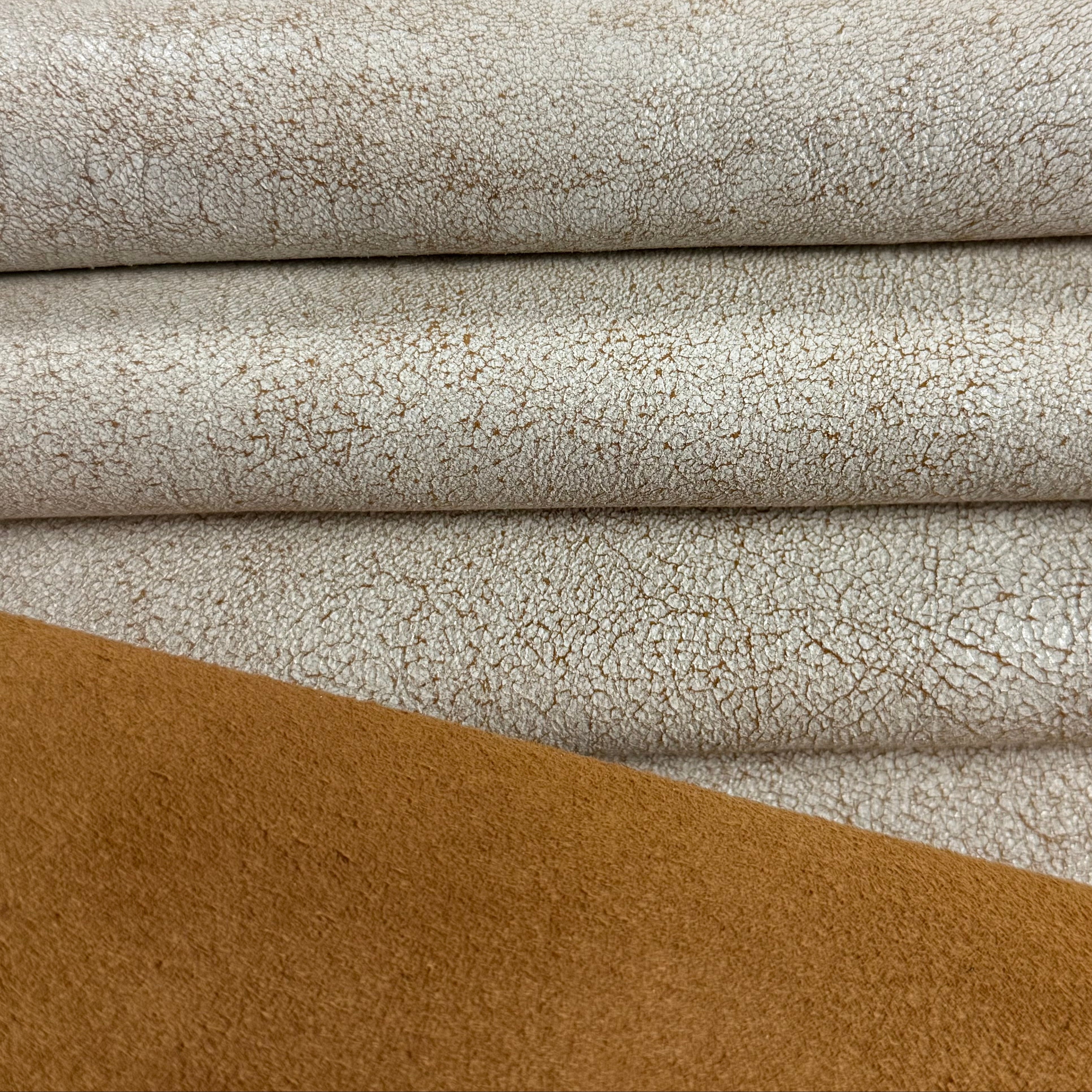 Crackle Leather in beige and tan, featuring a textured, distressed finish with layered fabric folds.