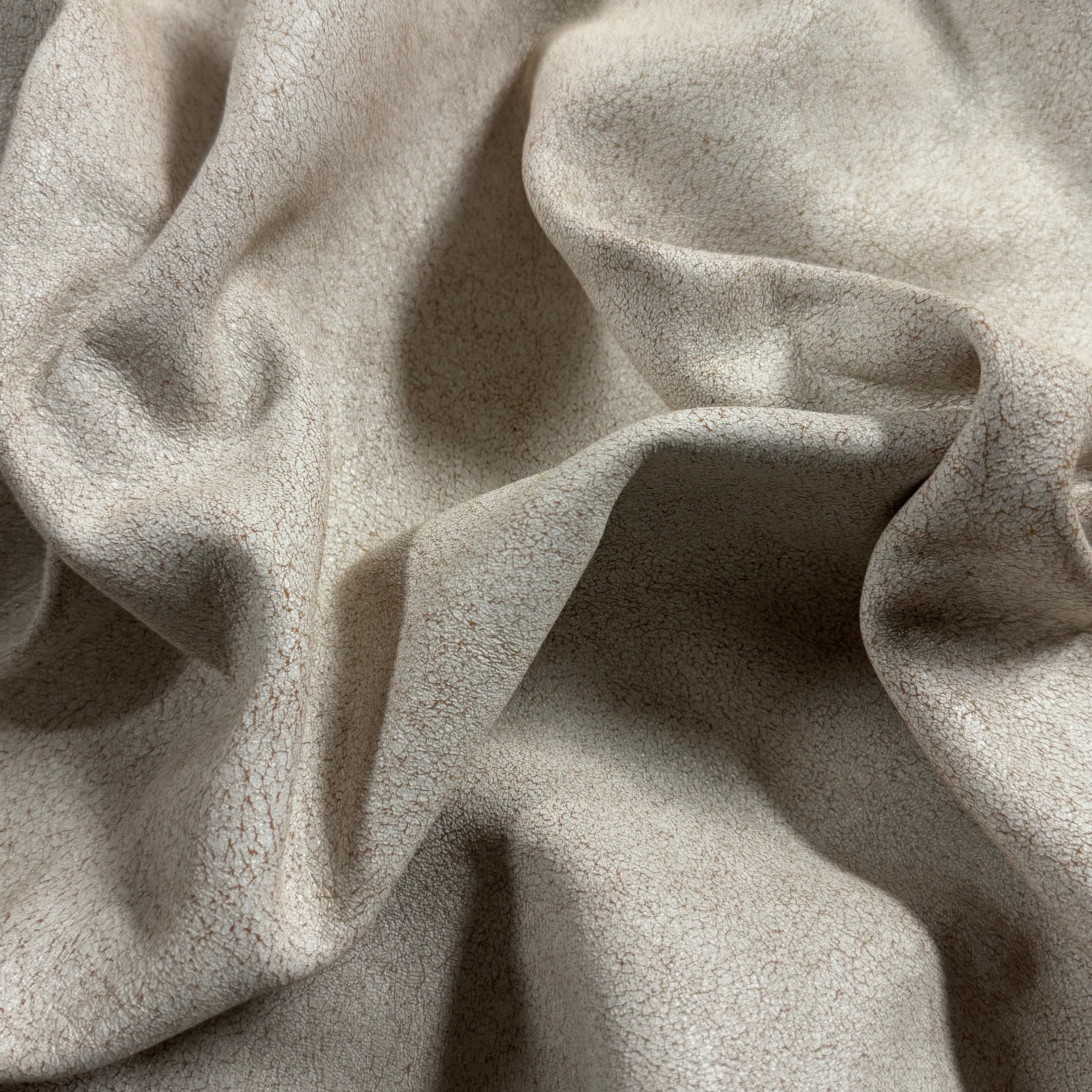 Crackle Leather in beige, featuring a soft, draped fabric with a textured, distressed vintage finish.