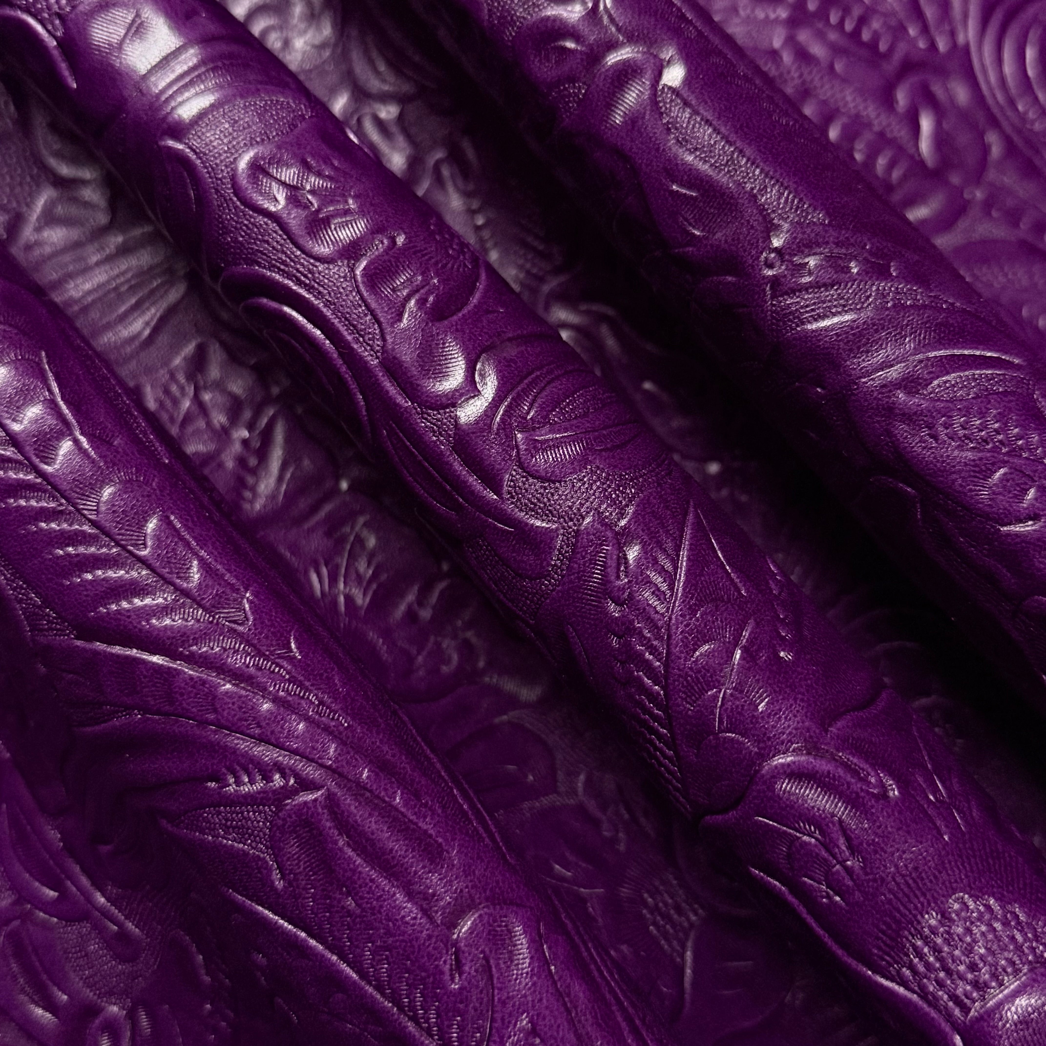 Deep purple floral embossed oiled veg tan lamb leather, showing its detailed pattern and supple texture.