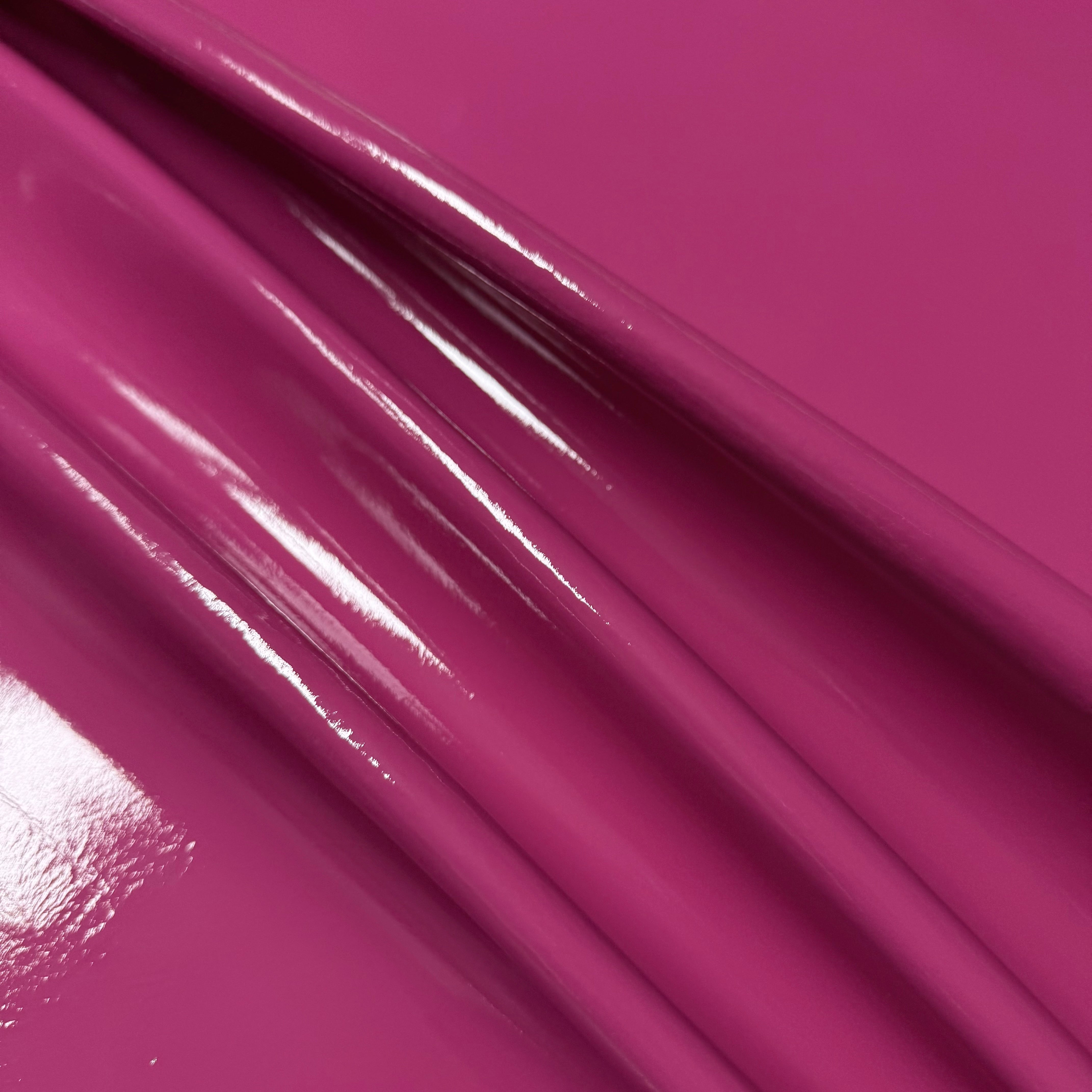 Patent Pig 1-2 oz leather in fuchsia, featuring a high-gloss, reflective patent finish with soft, draped folds.