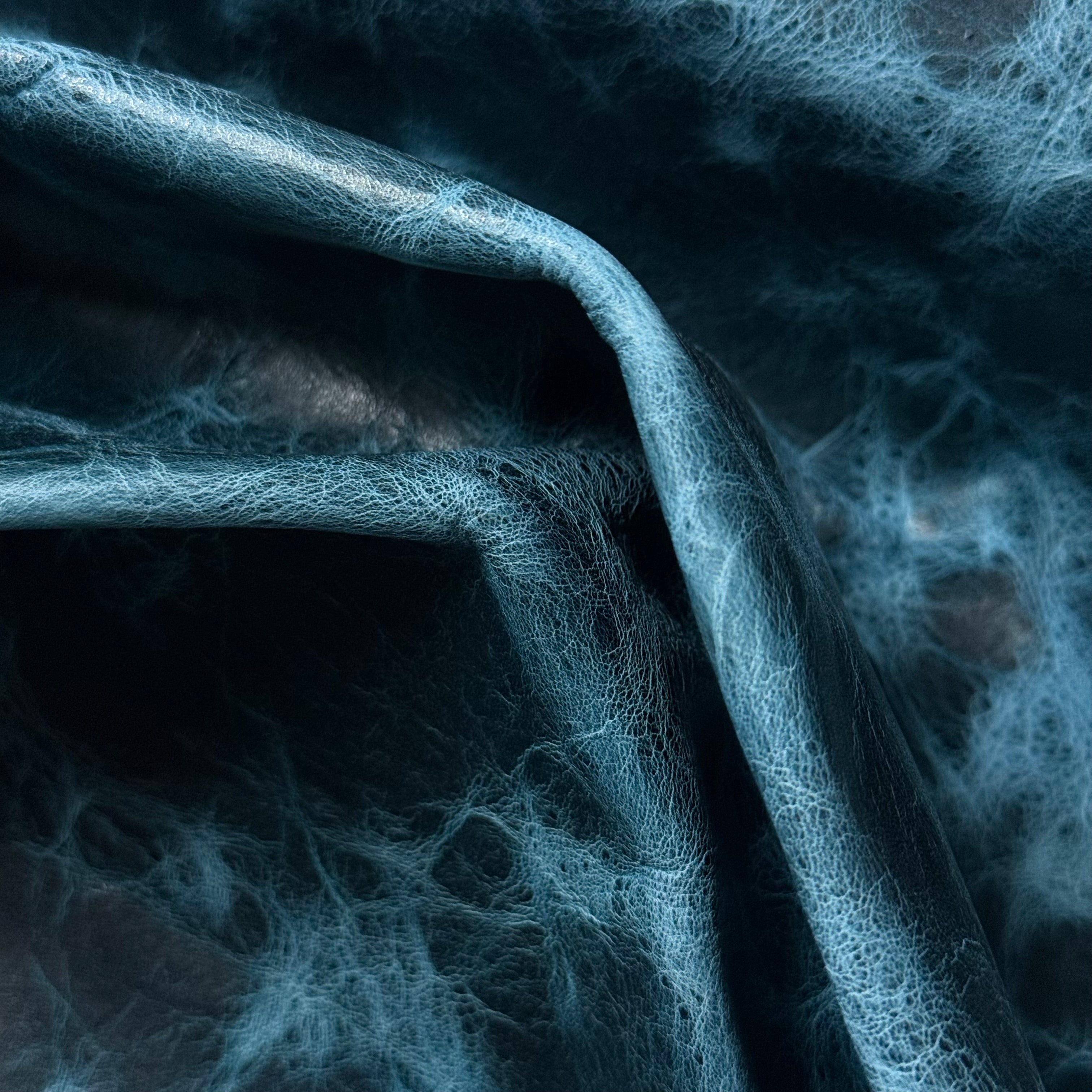 Blue Carnauba Waxed Pull-Up Cowhide leather, 2-3 oz, featuring a distressed, textured finish with deep blue tones.
