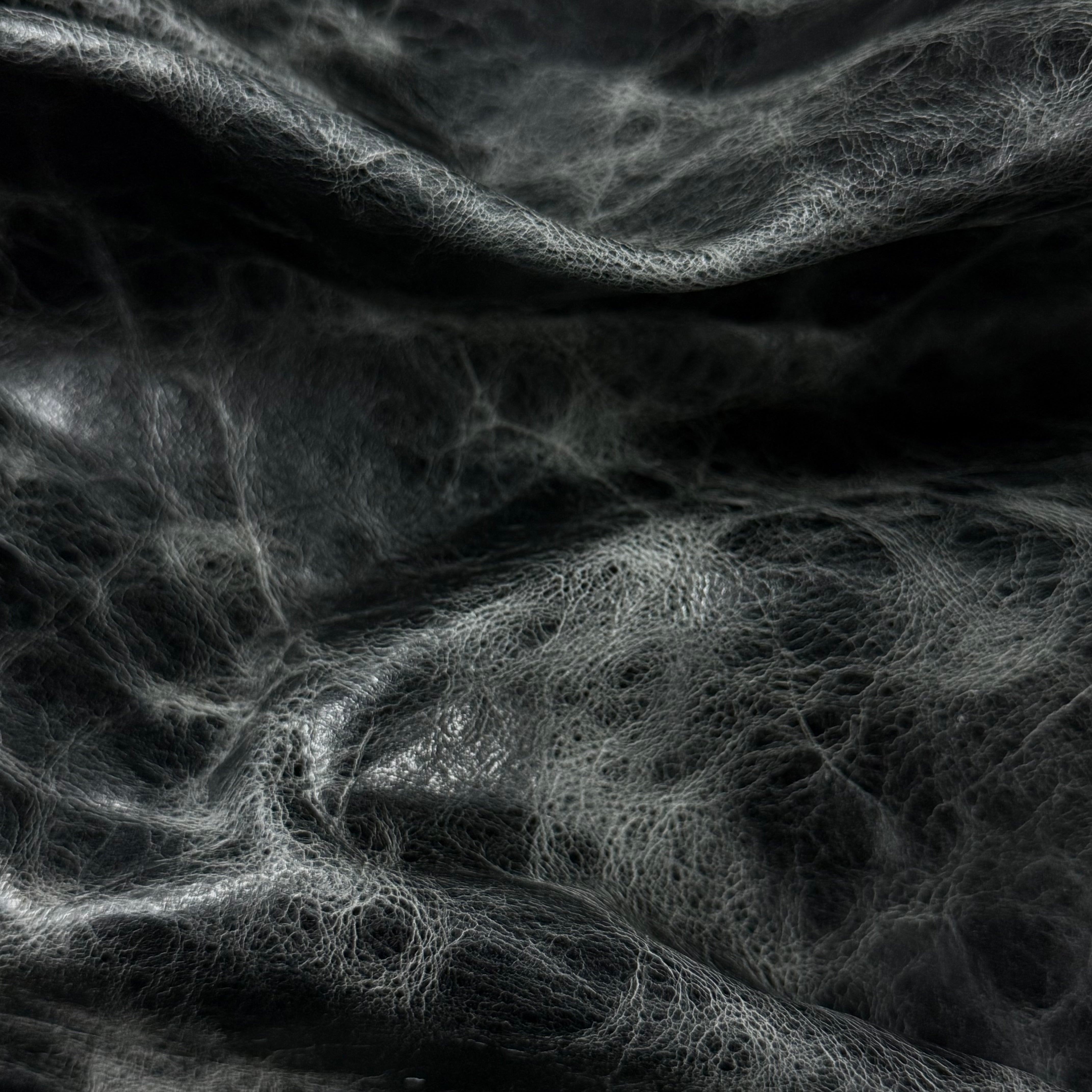Black Carnauba Waxed Pull-Up Cowhide leather, 2-3 oz, featuring a distressed, textured finish with deep folds.
