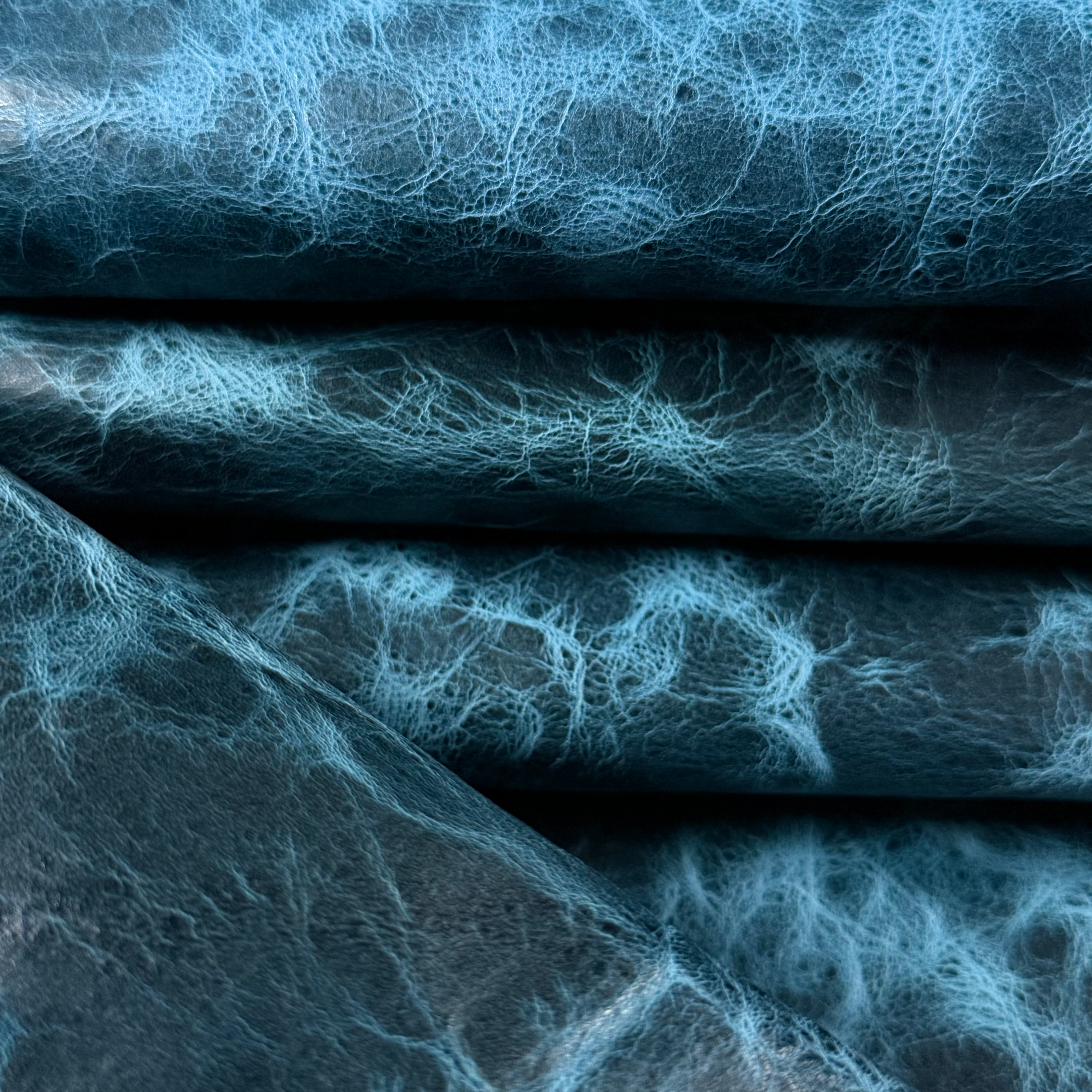 Blue Carnauba Waxed Pull-Up Cowhide leather, 2-3 oz, featuring a distressed, textured finish with deep blue tones.