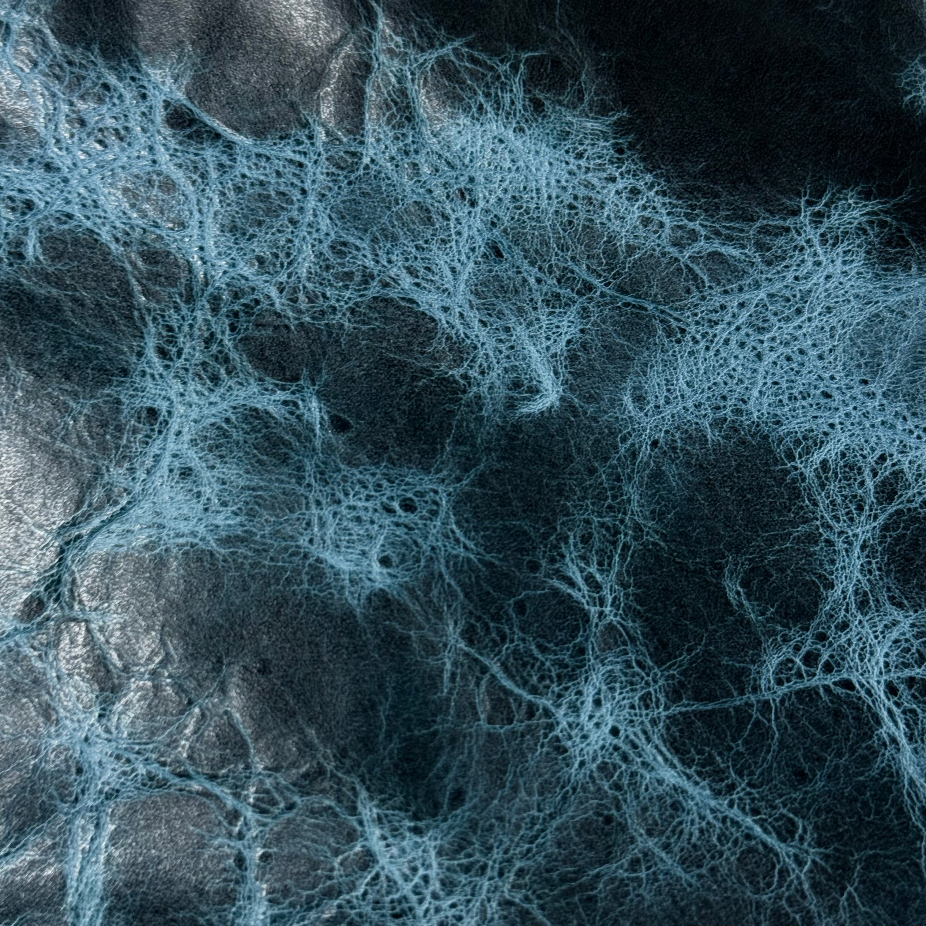 Blue Carnauba Waxed Pull-Up Cowhide leather, 2-3 oz, featuring a textured, distressed finish with deep blue and black tones.