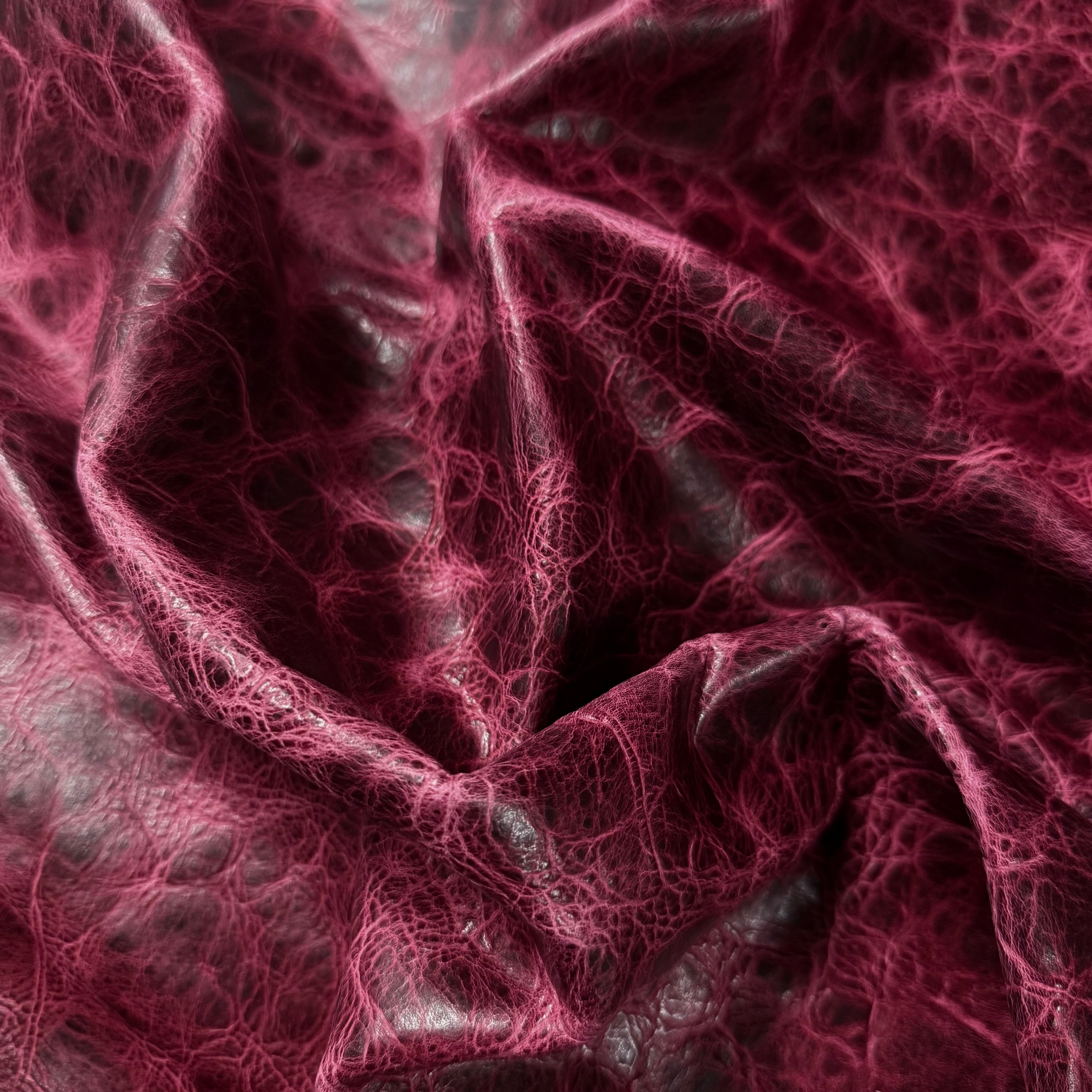 Burgundy Carnauba Waxed Pull-Up Cowhide, 2-3 oz leather with a distressed, textured finish and deep creases.