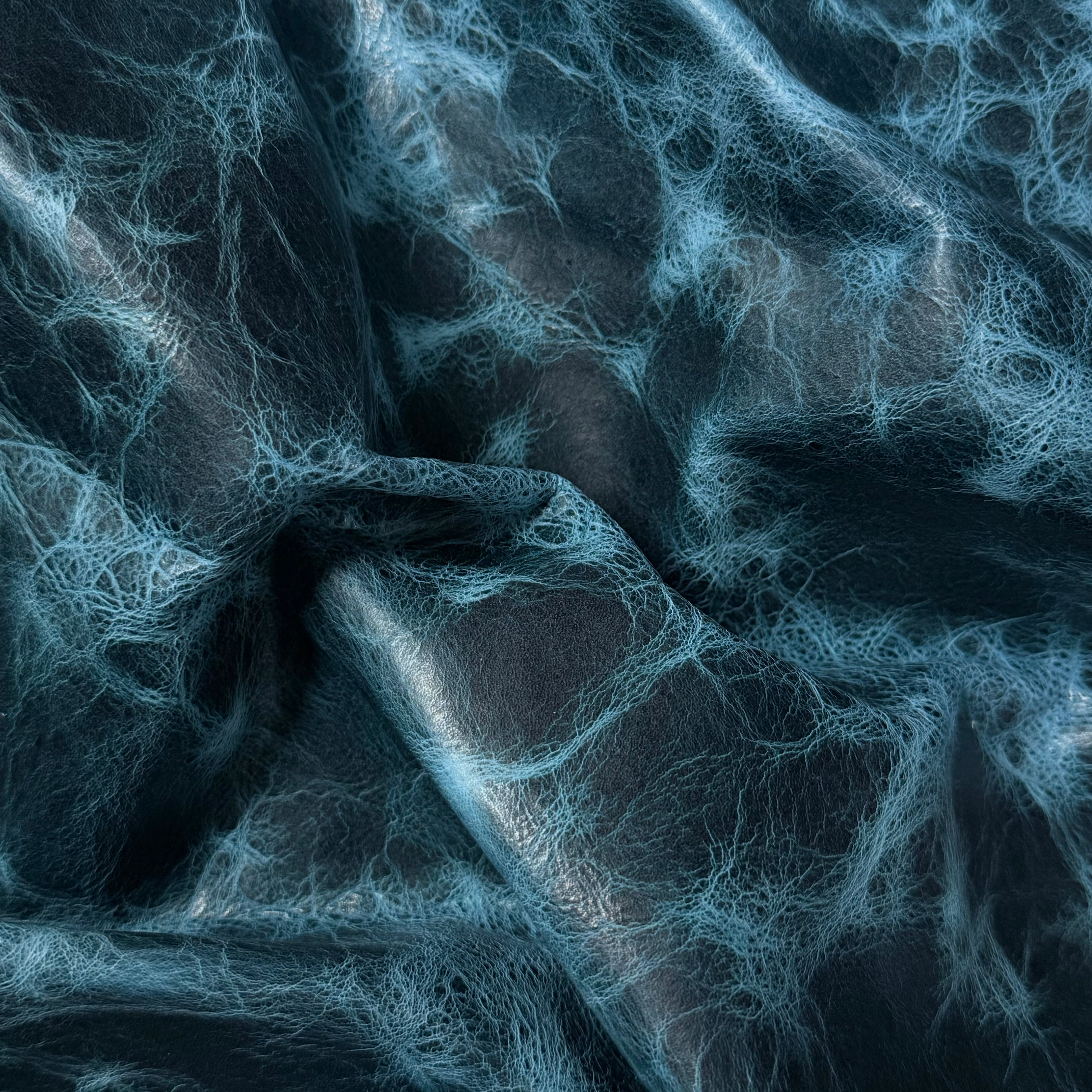 Blue Carnauba Waxed Pull-Up Cowhide leather, 2-3 oz, featuring a distressed, marbled texture and soft, folded finish.
