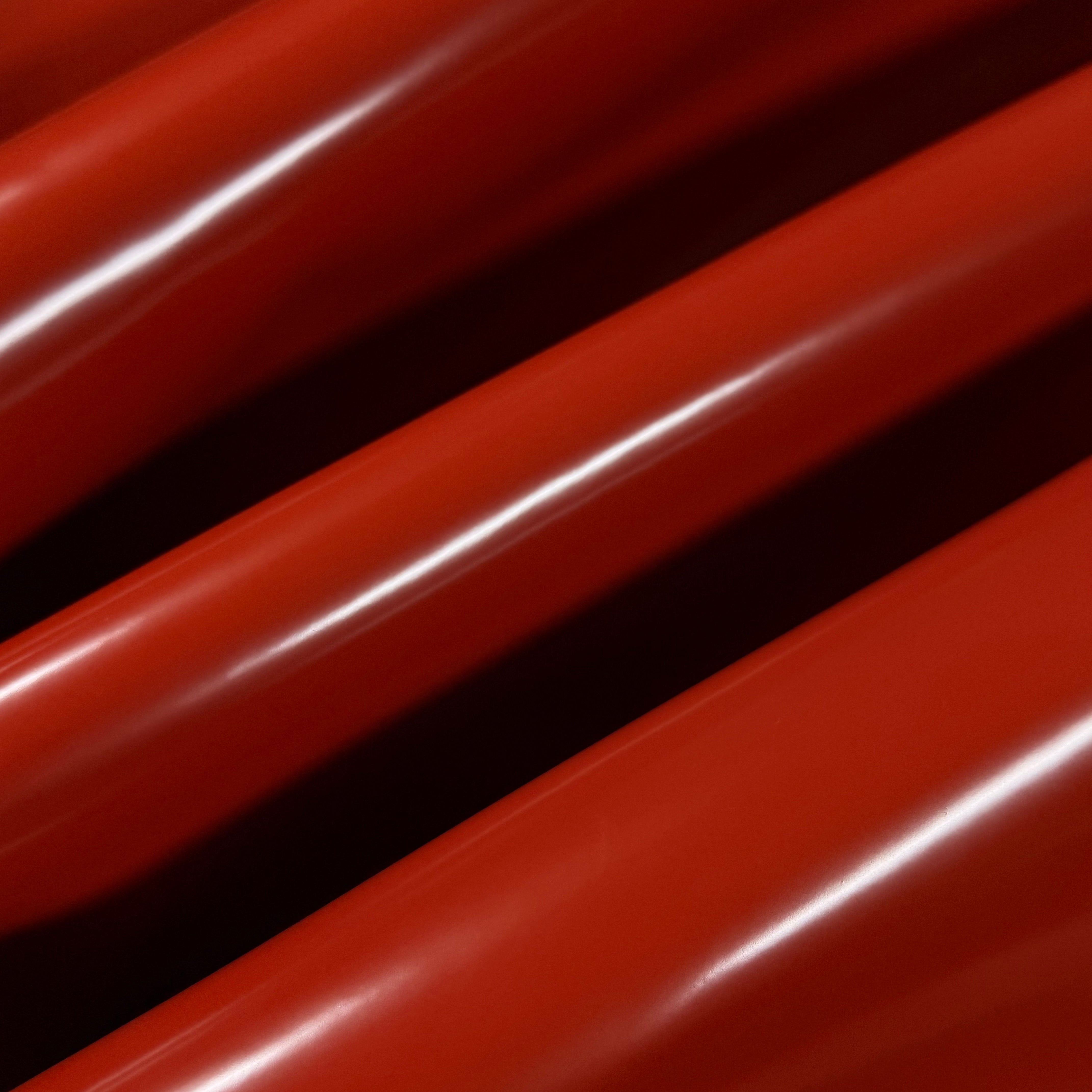 Smooth, polished red cowhide leather with a high-gloss finish, showing its luxurious texture.