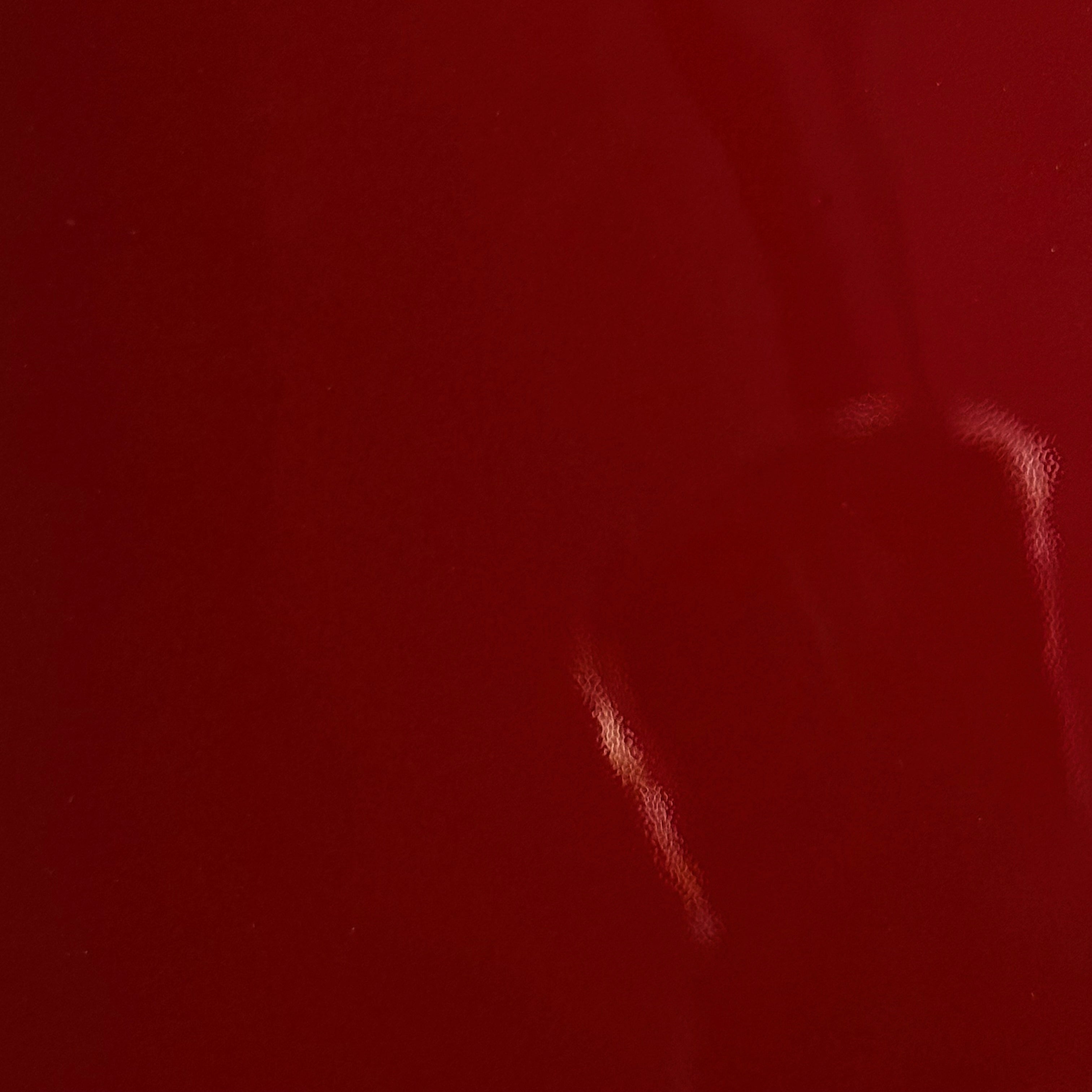 Luxury red patent cow leather with a glossy lacquer finish and smooth texture.