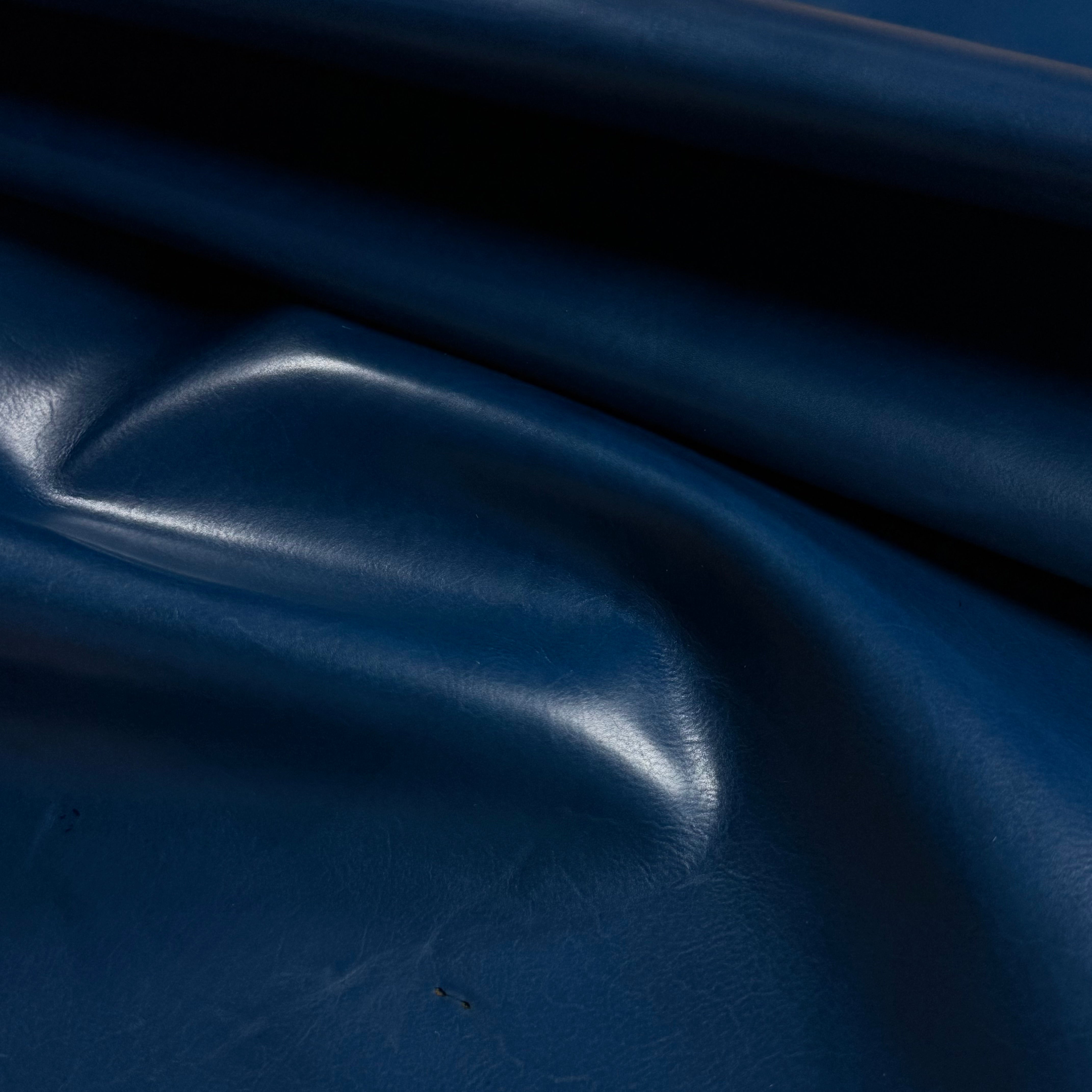 Smooth, polished navy blue vegetable-tanned baby calf leather with natural shine and subtle texture.
