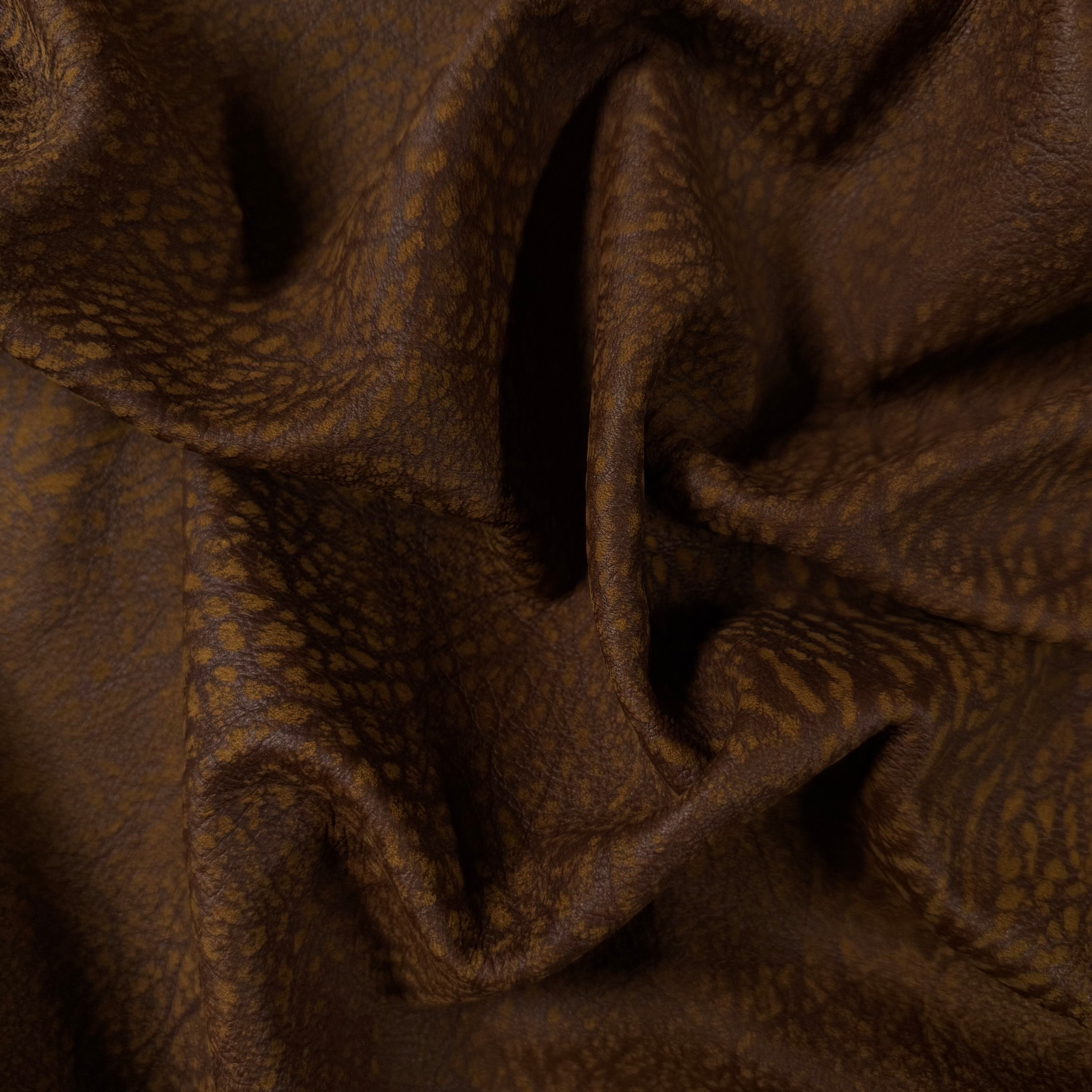 Brown Distressed Buffed Elephant Embossed Cowhide, 3 oz leather with a textured, rugged grain and soft, folded drape.