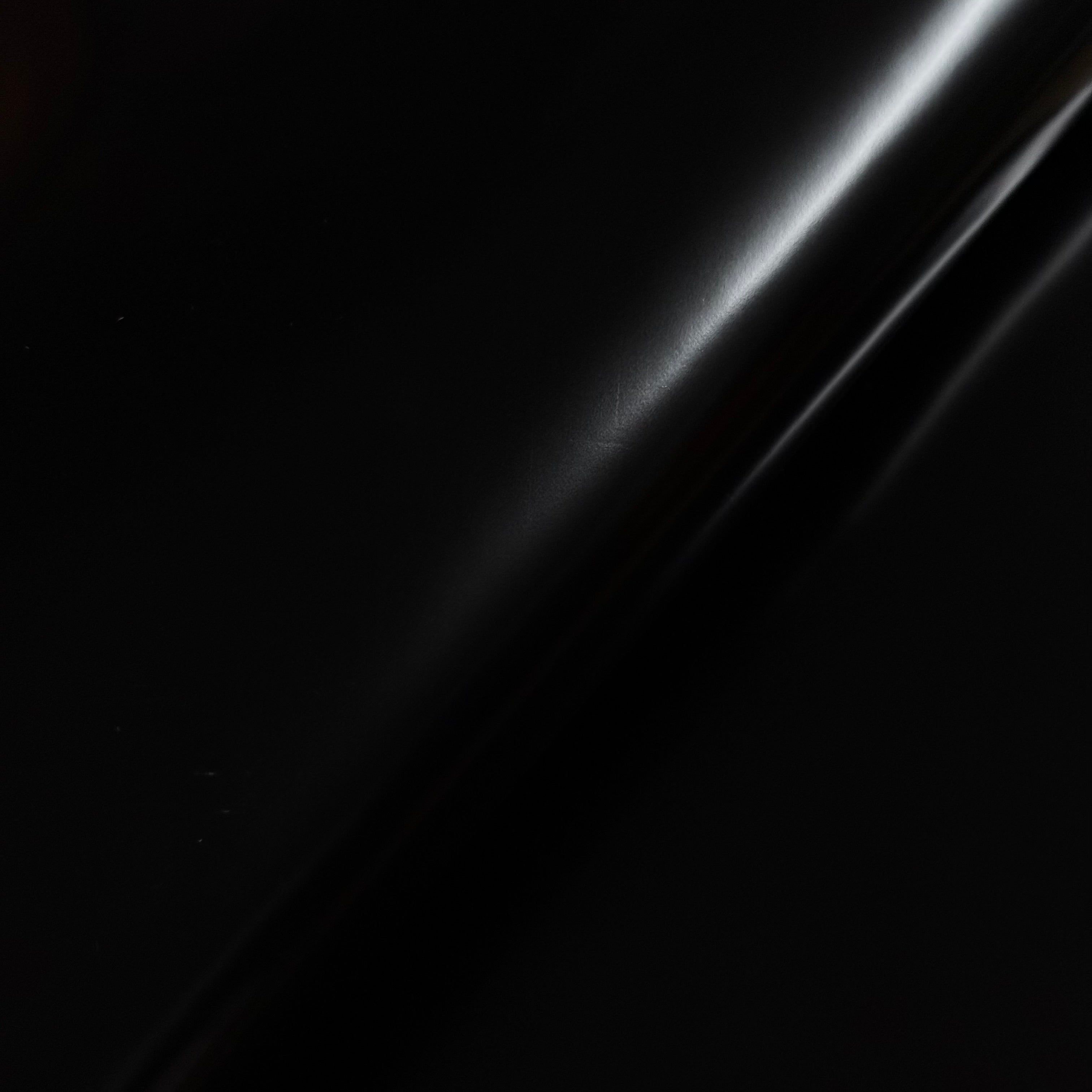 Smooth polished black cowhide leather with a high-gloss finish, reflecting light.