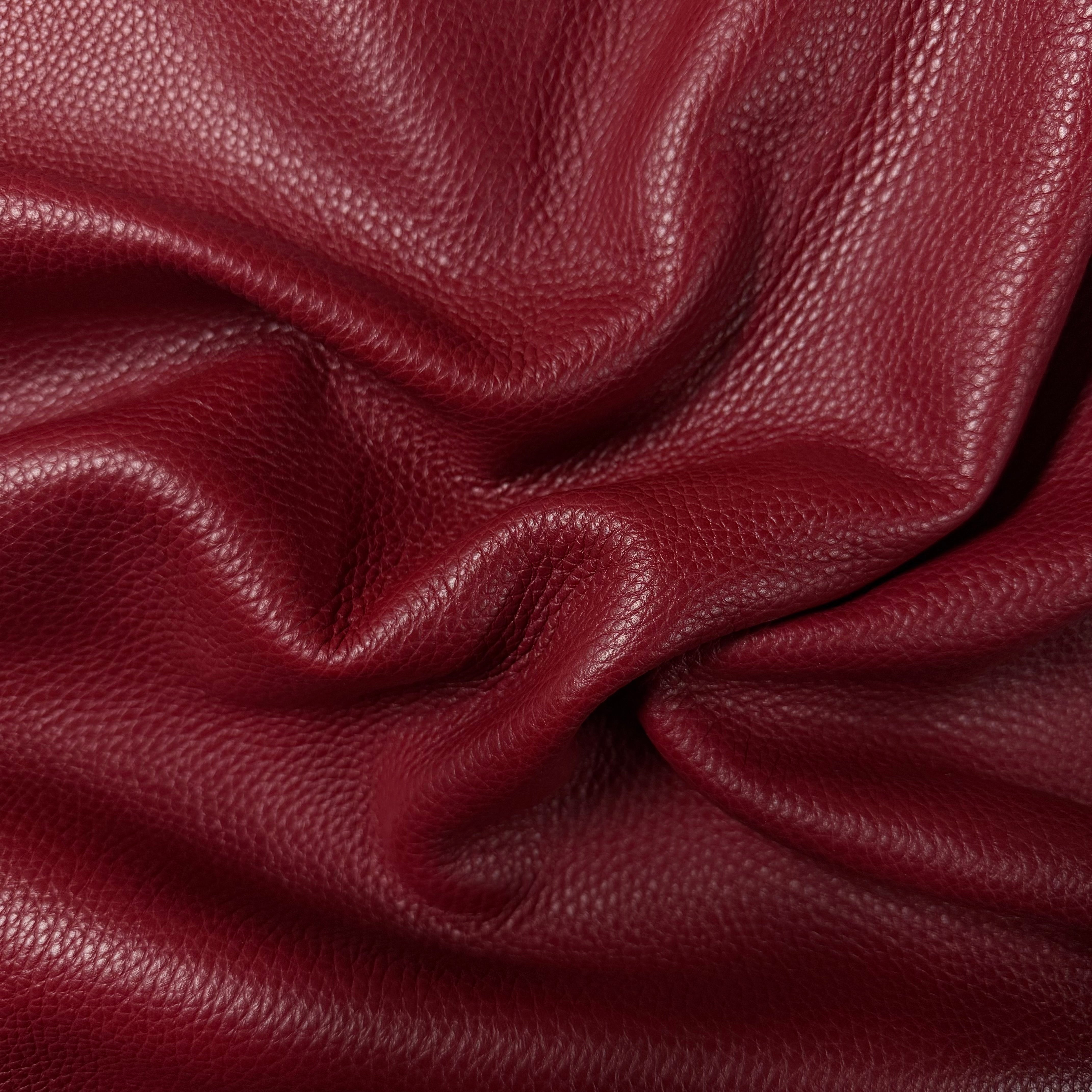 Deep red Pebble Grain Calf leather, 3-4 oz, featuring a soft, textured surface with natural folds and a matte finish.