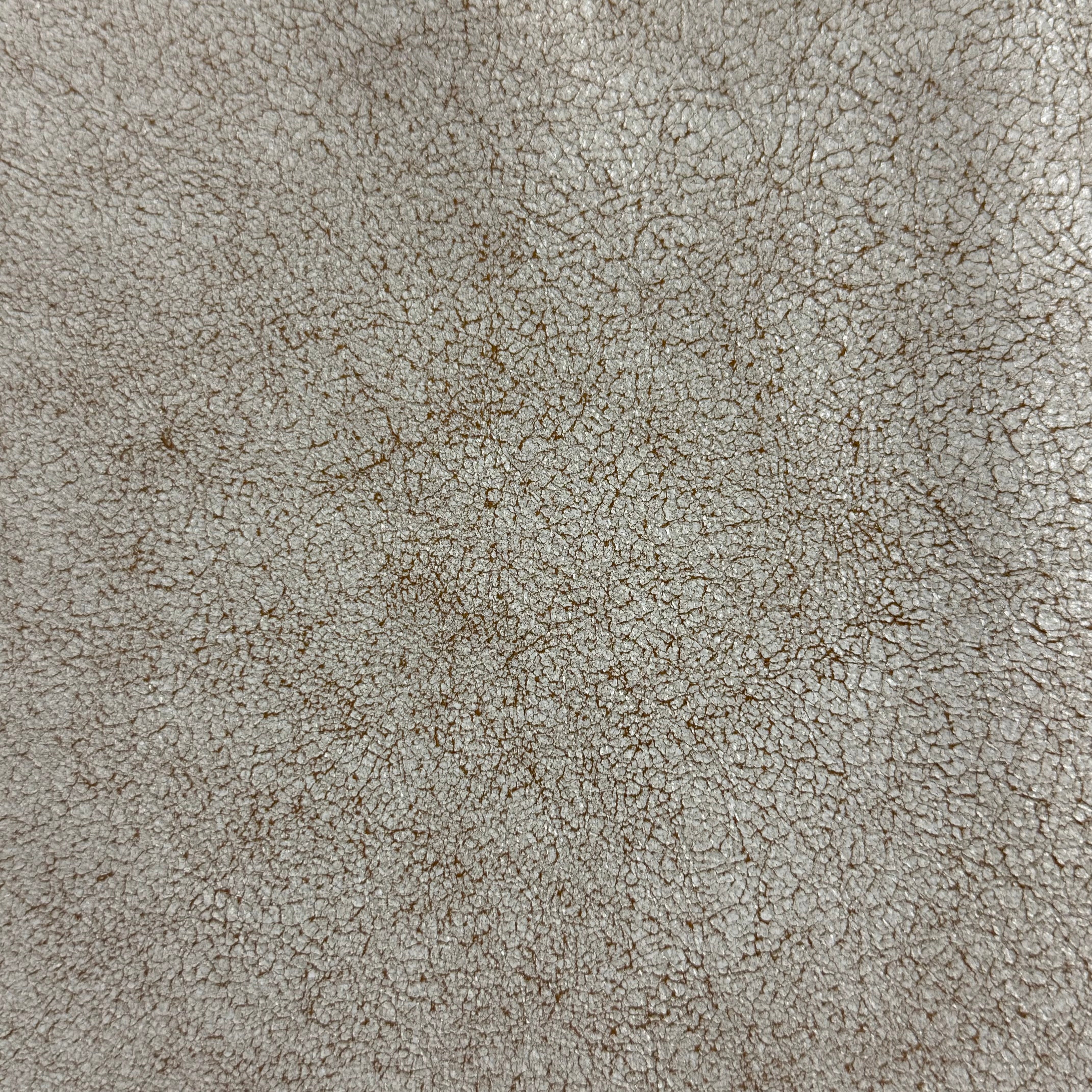 Crackle Leather in beige, featuring a textured, distressed surface with a fine, web-like pattern and matte finish.