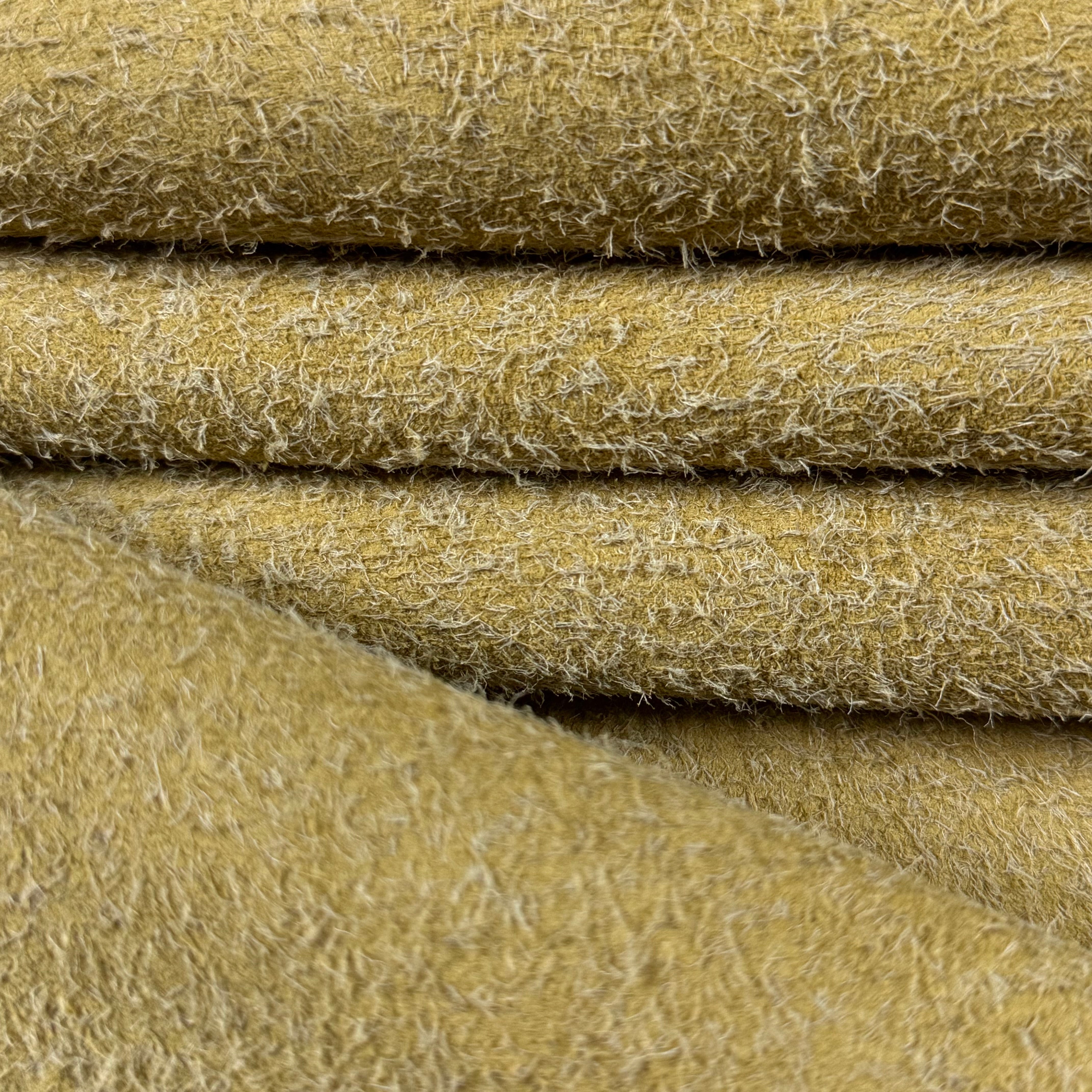 Stacked mustard yellow hairy calf suede bends with long, shaggy fibers and a rough-out texture.